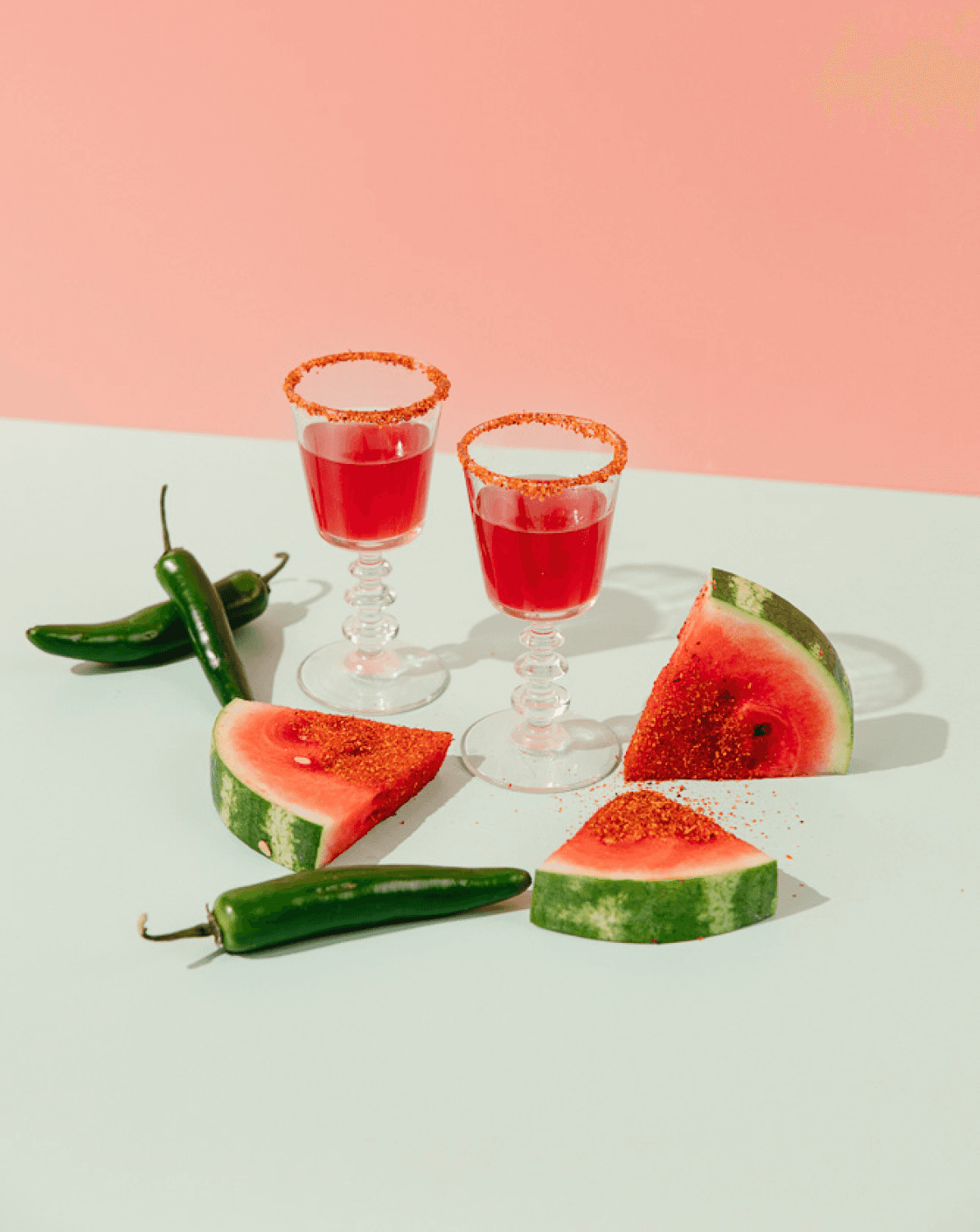 Watermelon slices and jalapeños surround two spicy shootie mocktails