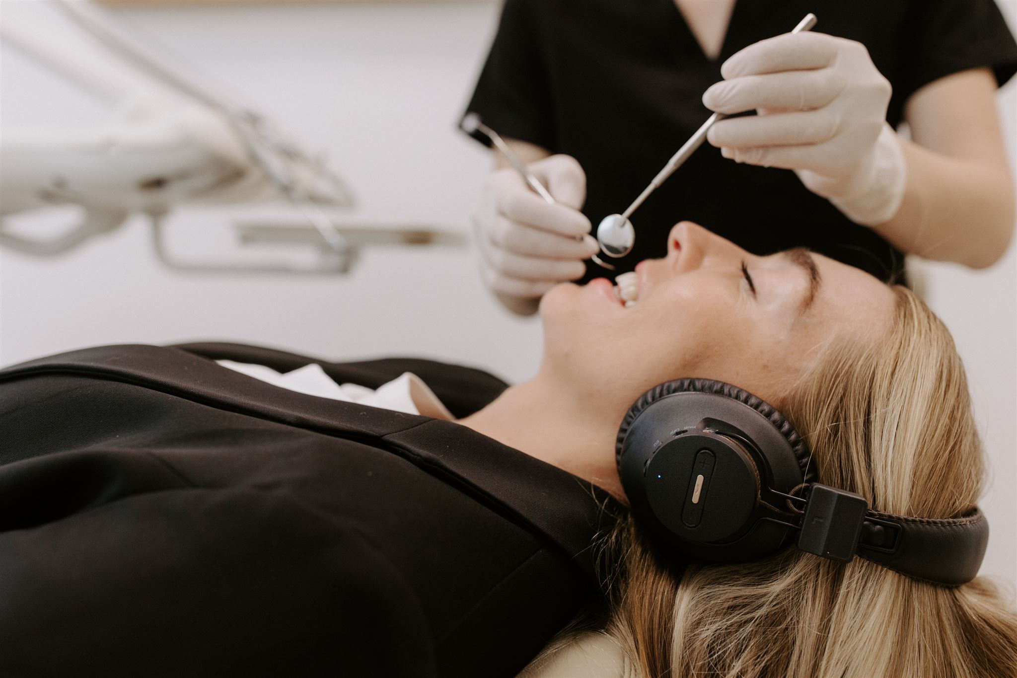 Dental patient using noise cancelling headphone for a comfortable dental experience