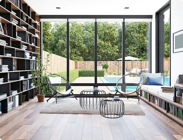 Bright home library and workspace with large windows, bookshelves, and natural greenery view