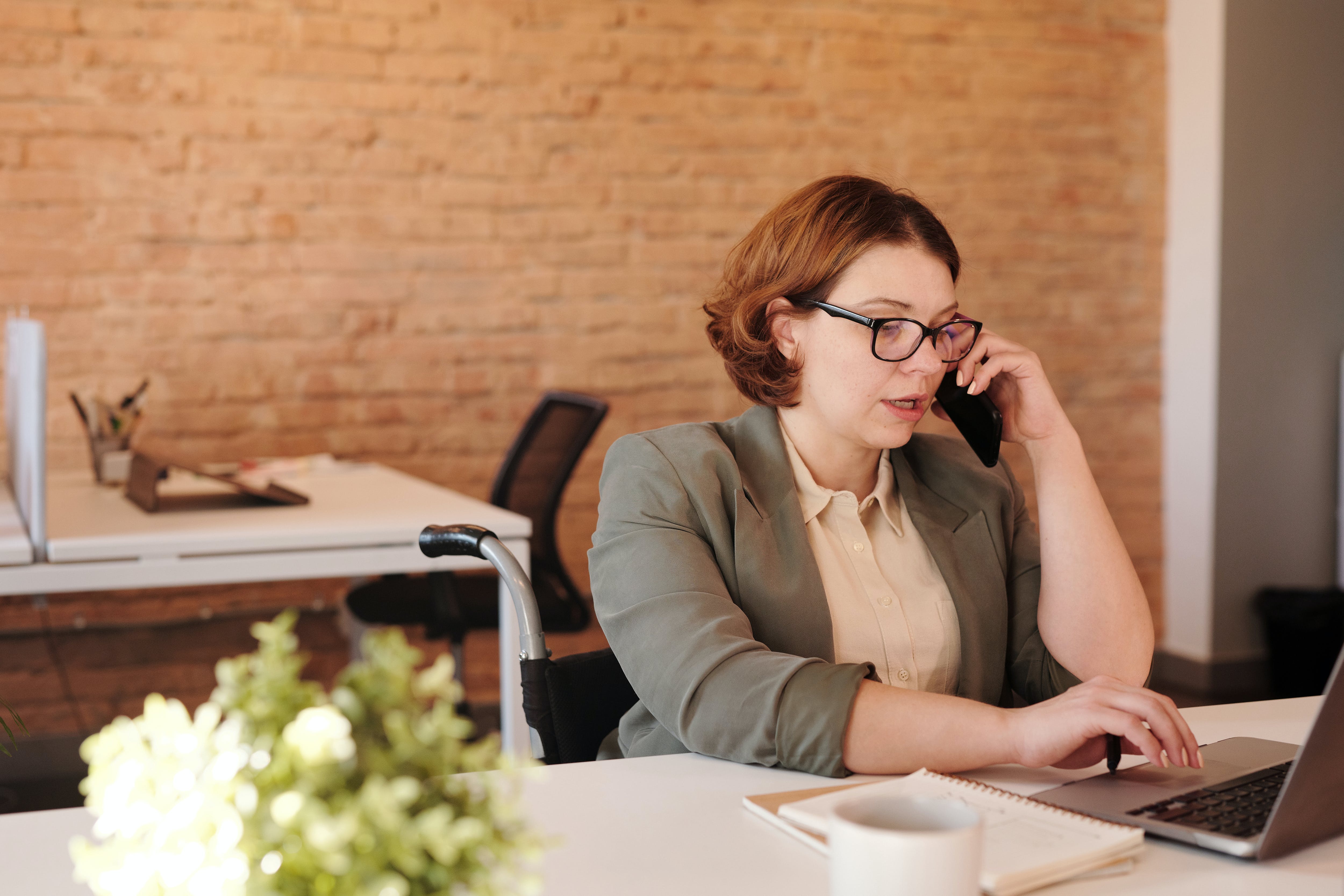 Woman sending cold emails in the UK while talking through smartphone