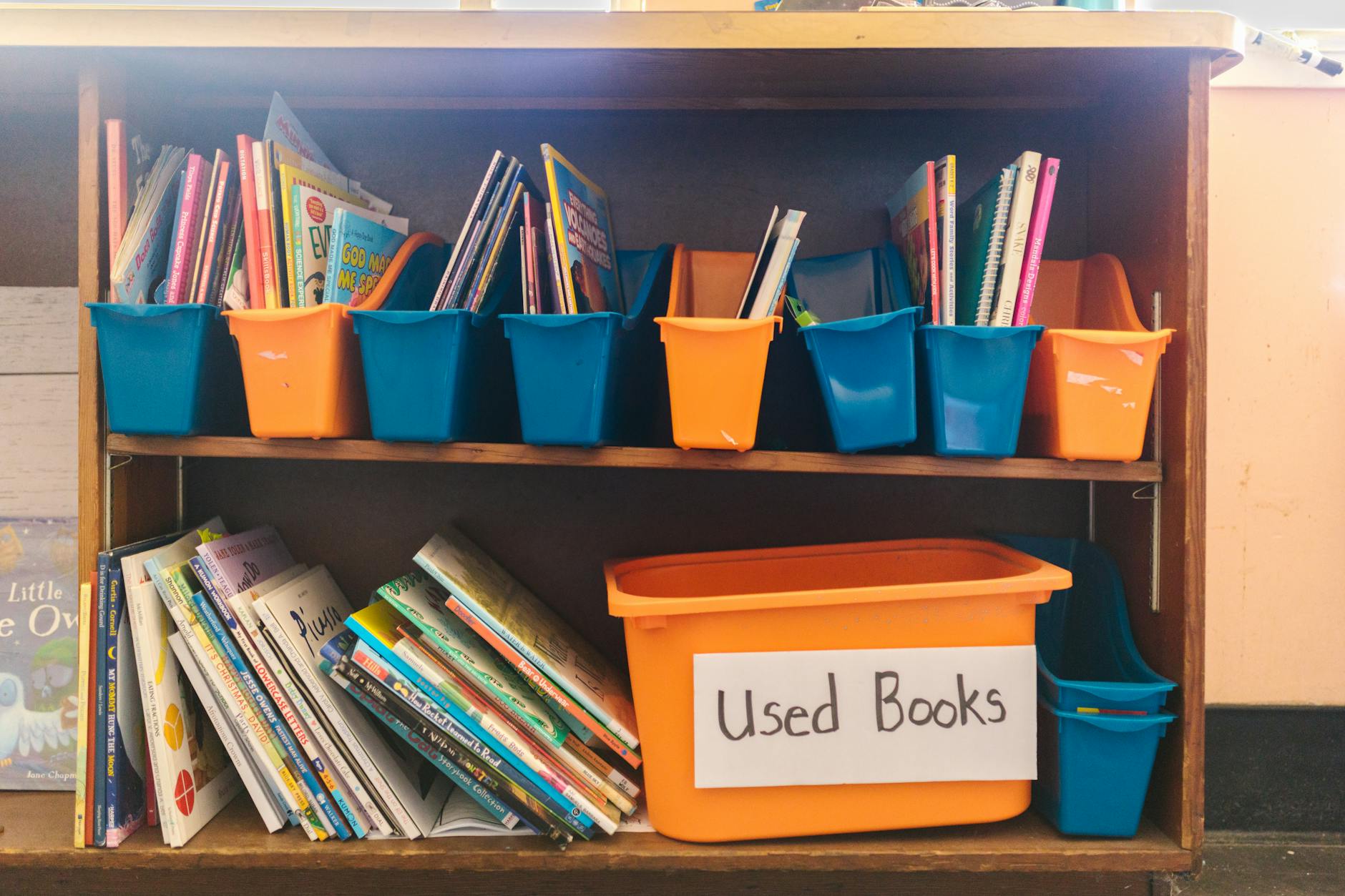 A tidy storage cabinet filled with labeled bins of sensory toys and essential resource teacher resources.