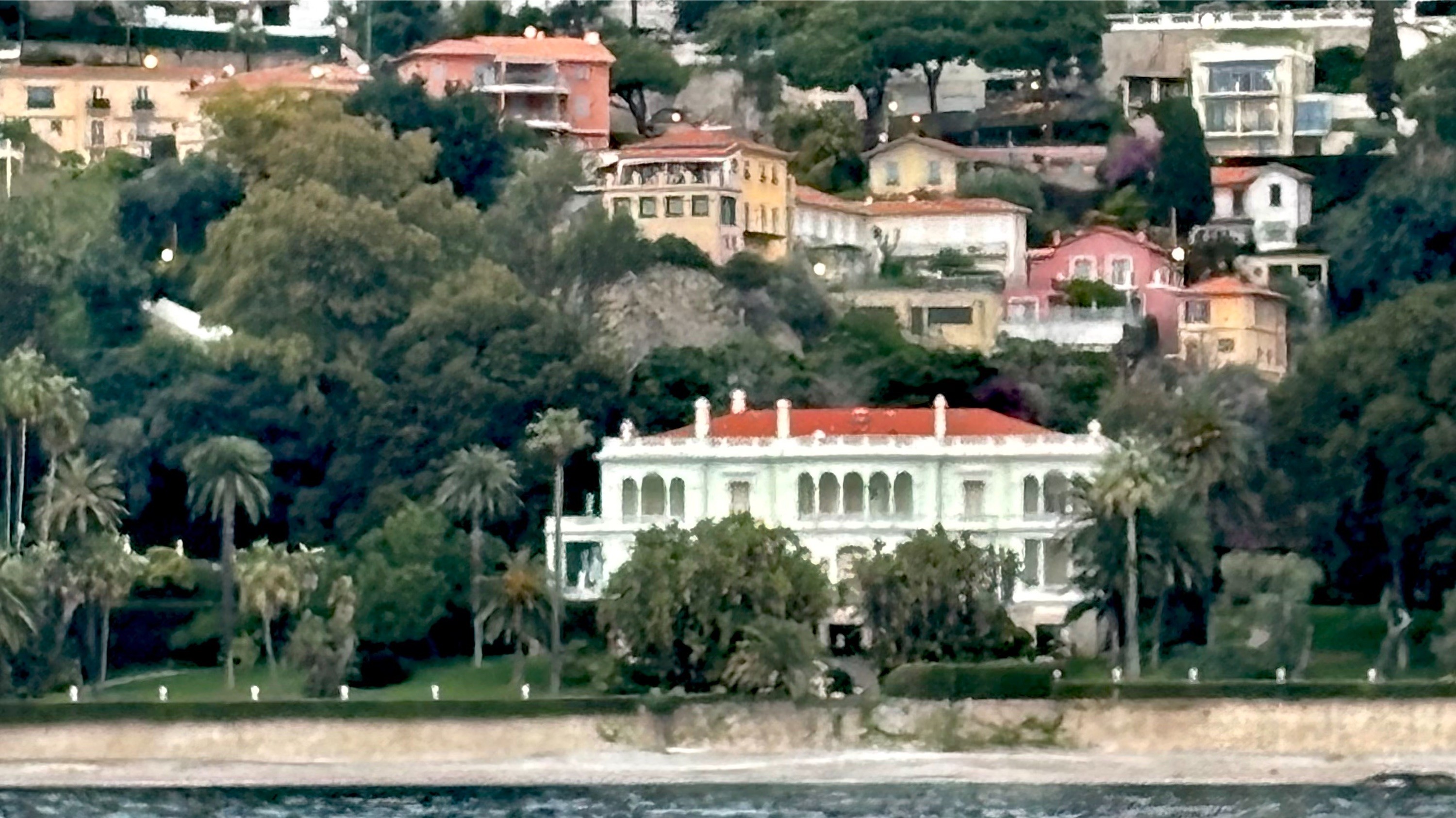 Villas on a wooded hillside above the water, east of Monaco