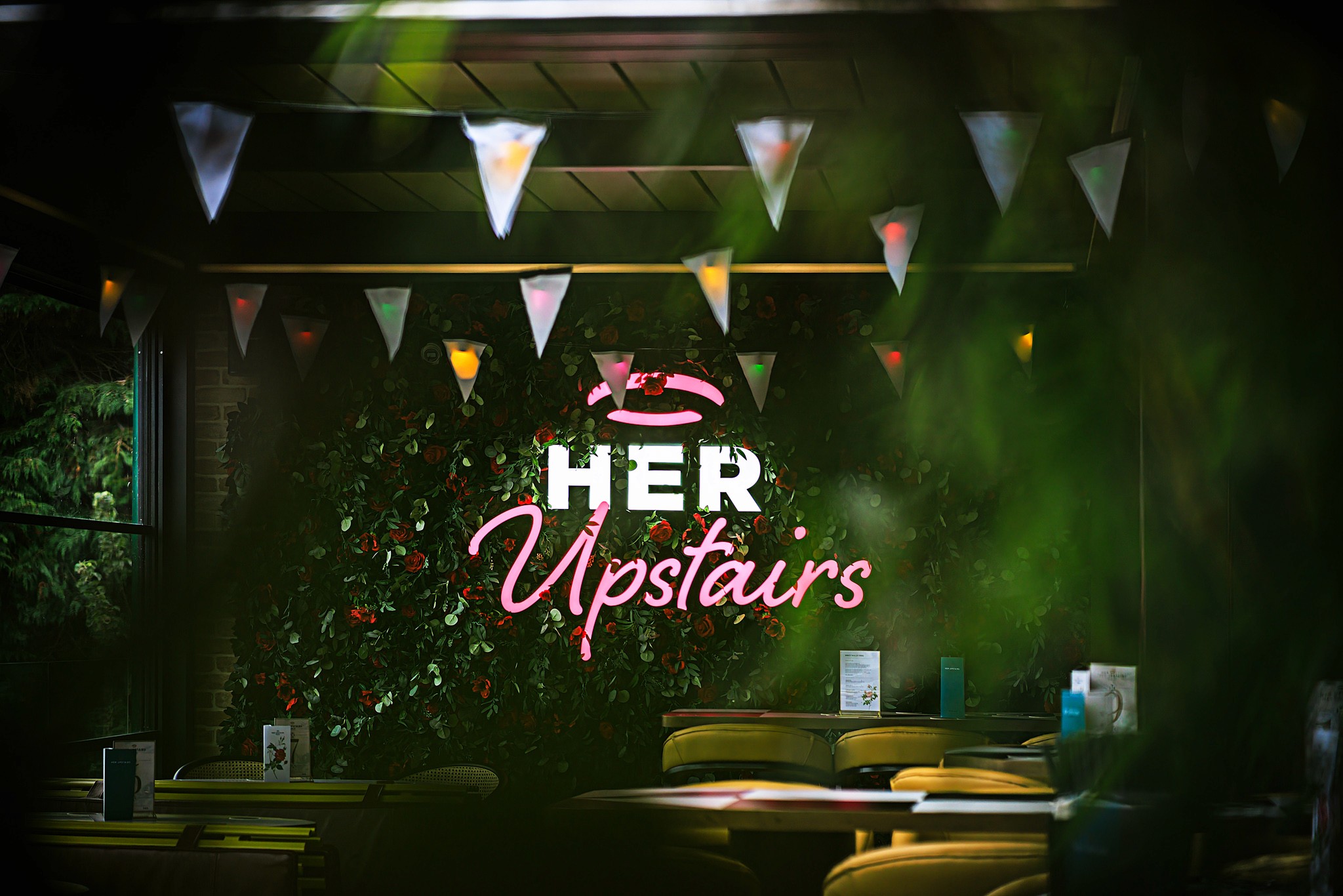 Interior shot of Her Upstairs neon sign
