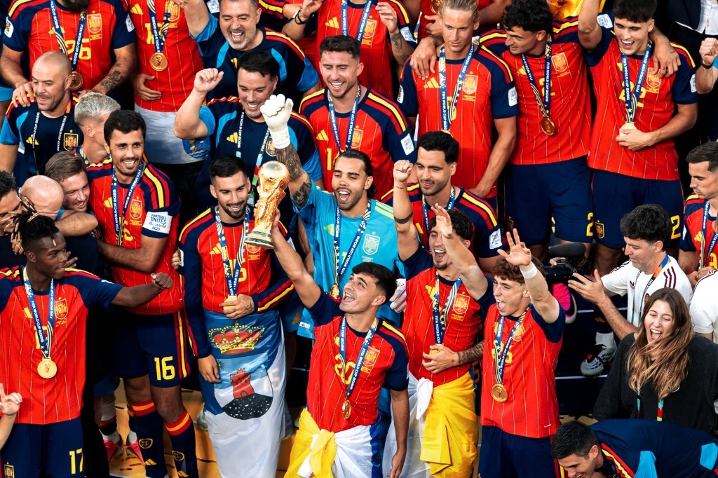 Spain goalkeeper David Raya lifts the World Cup trophy as Pedri, Gavi, Nico Williams, and teammates celebrate