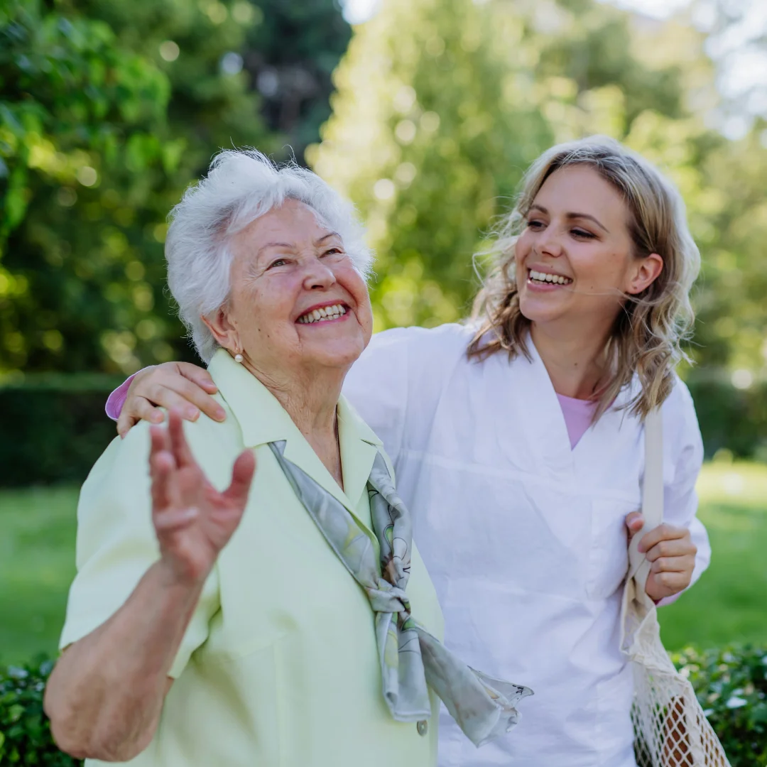Community nurse with older woman laughing together outdoors in Brisbane
