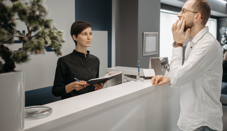 a patient talks to front desk staff