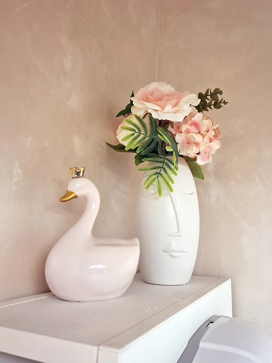 Kosmetoloģijas kabineta interjera detaļa ar ziediem un dekoratīvu figūru