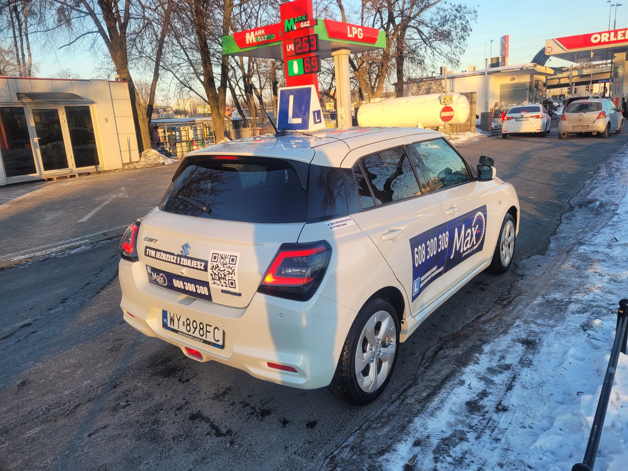 Two individuals are working out in a gym, focusing on dumbbells and strength training equipment.
