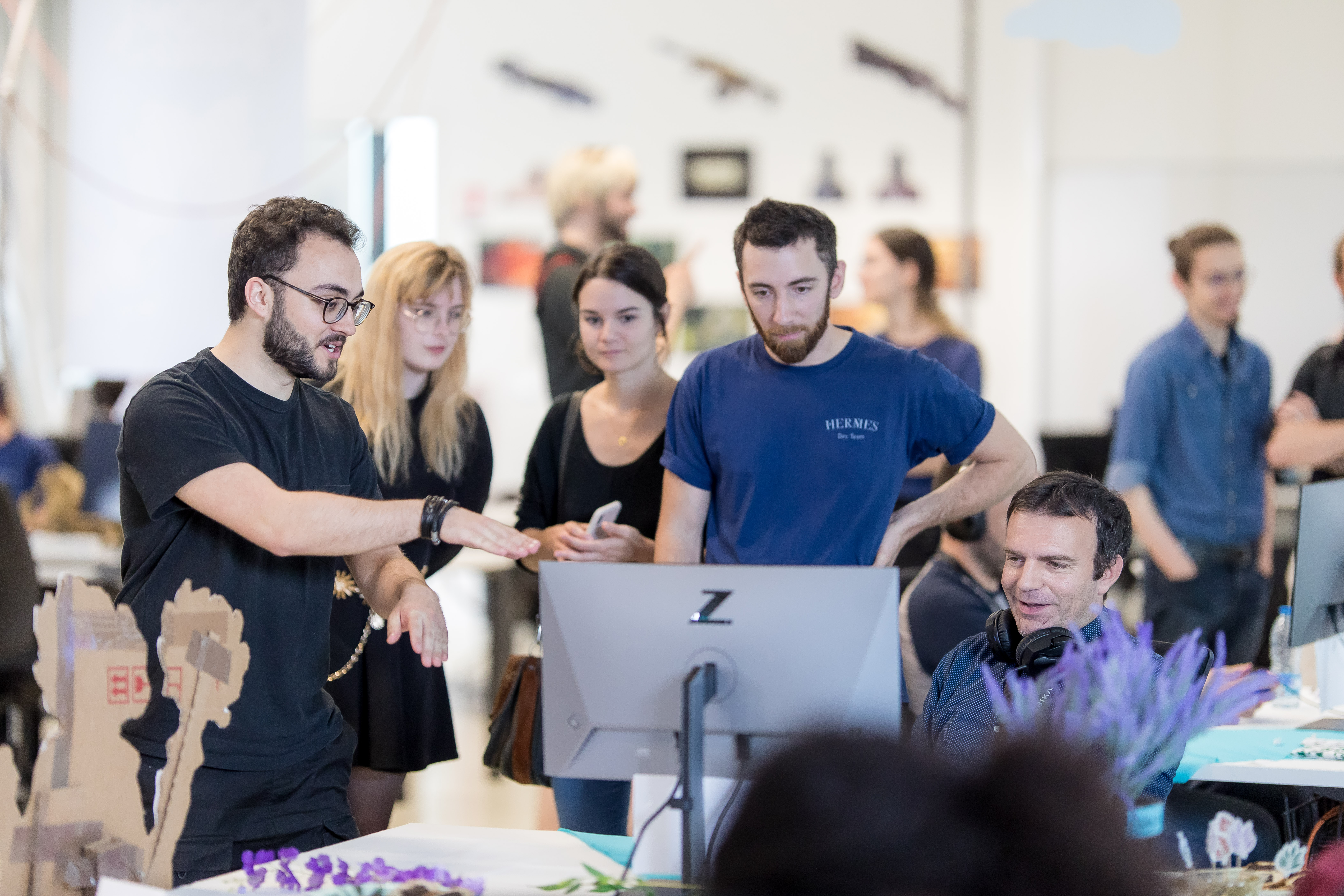 Équipe de travail collaborant autour d'un ordinateur dans un bureau moderne.