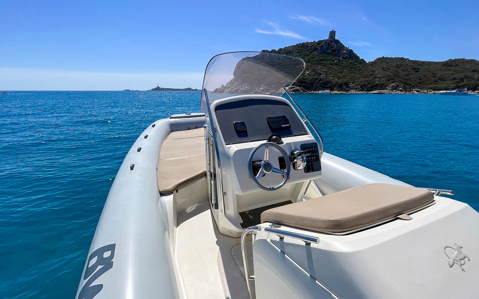 Boat cruising in the Gulf of Cagliari with coastal hills in the background.