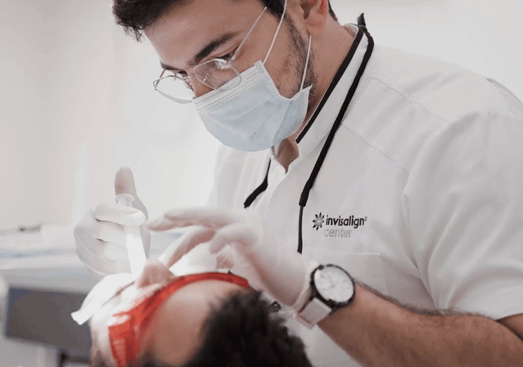 An orthodontist performing a treatment on a patient, specializing in orthodontics by Invisalign Center