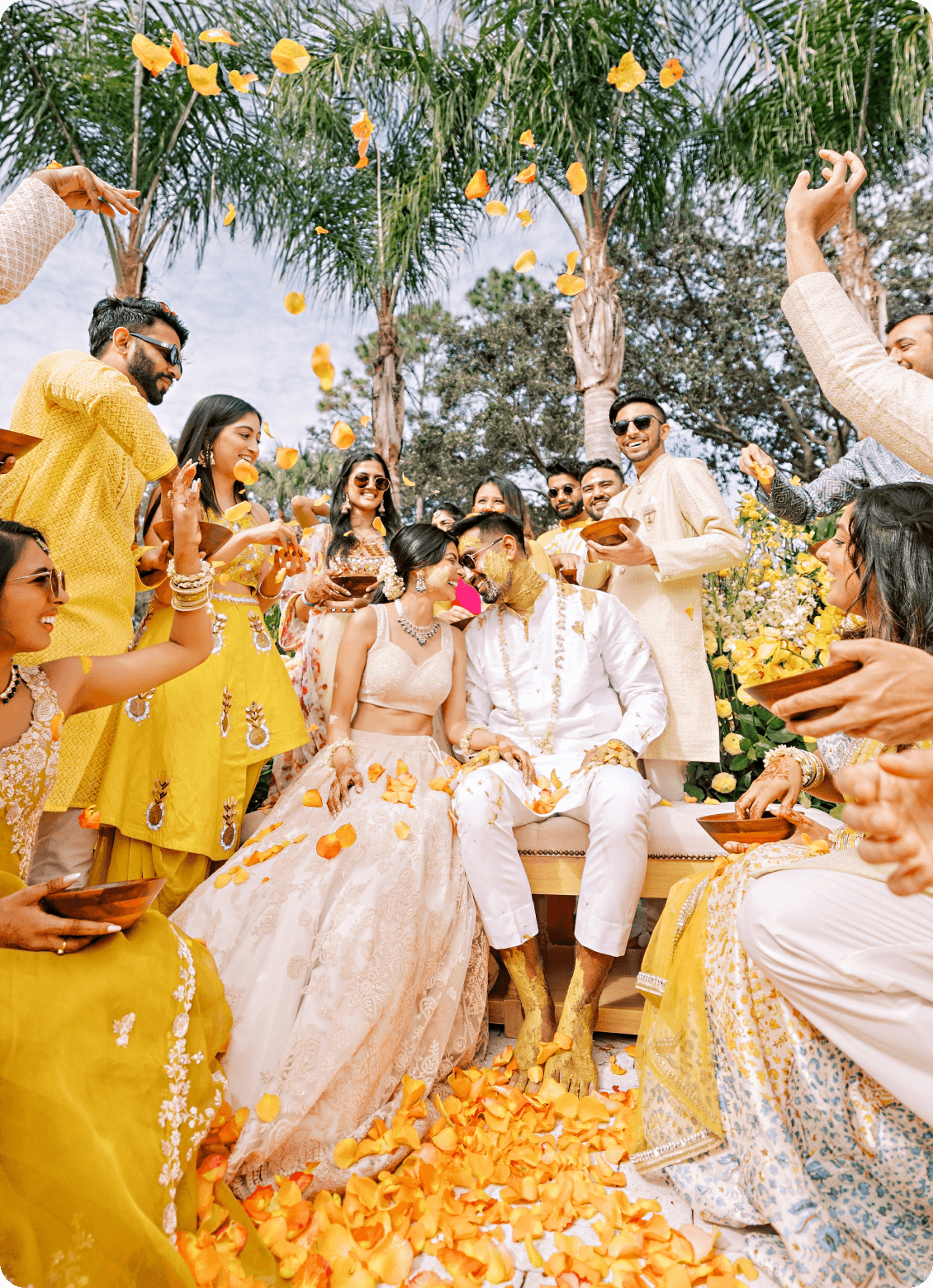 Happy couple celebrating at their wedding with guests throwing flowers