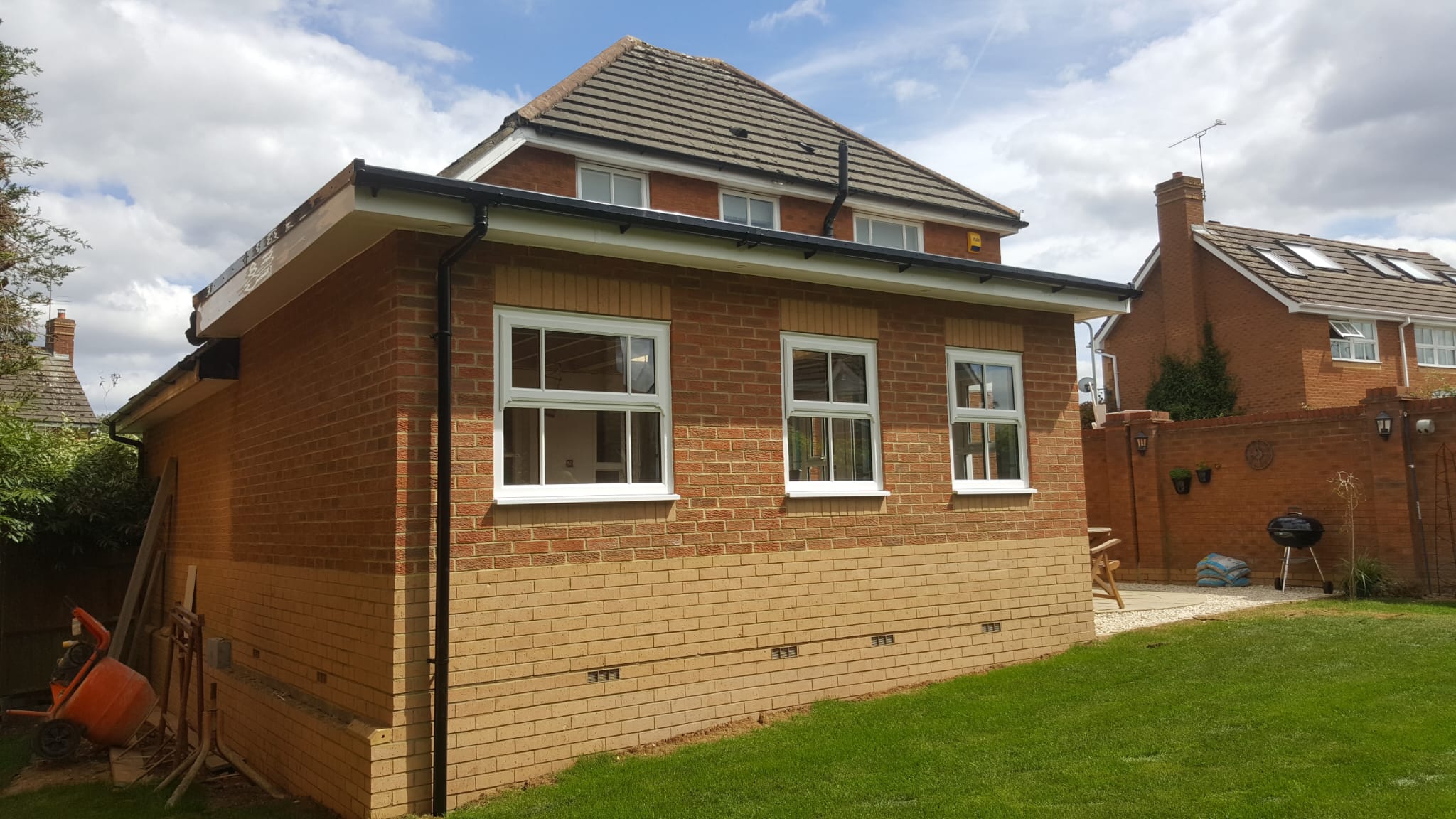 brown brick house near green trees during daytime