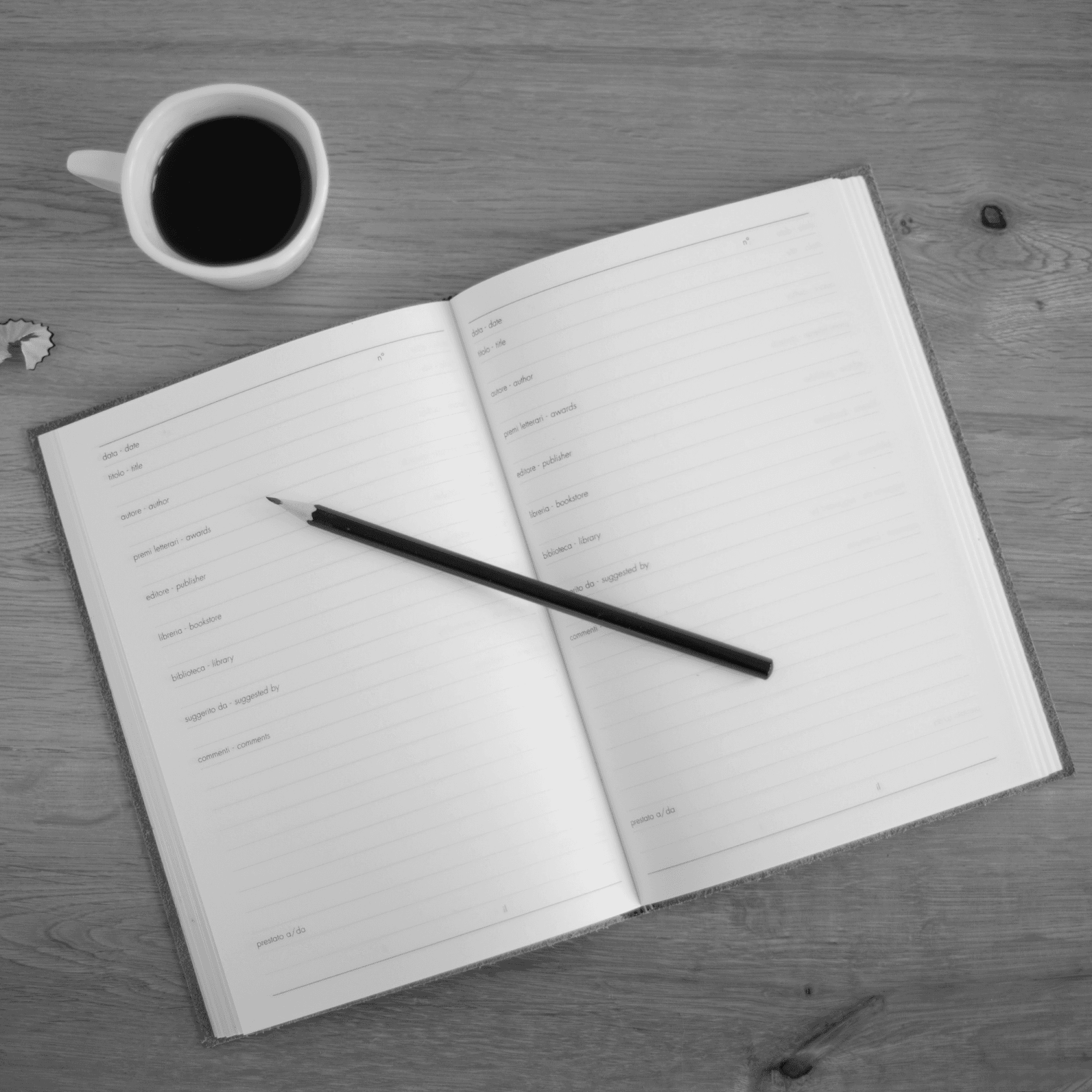 Open diary with pencil and coffee on desk