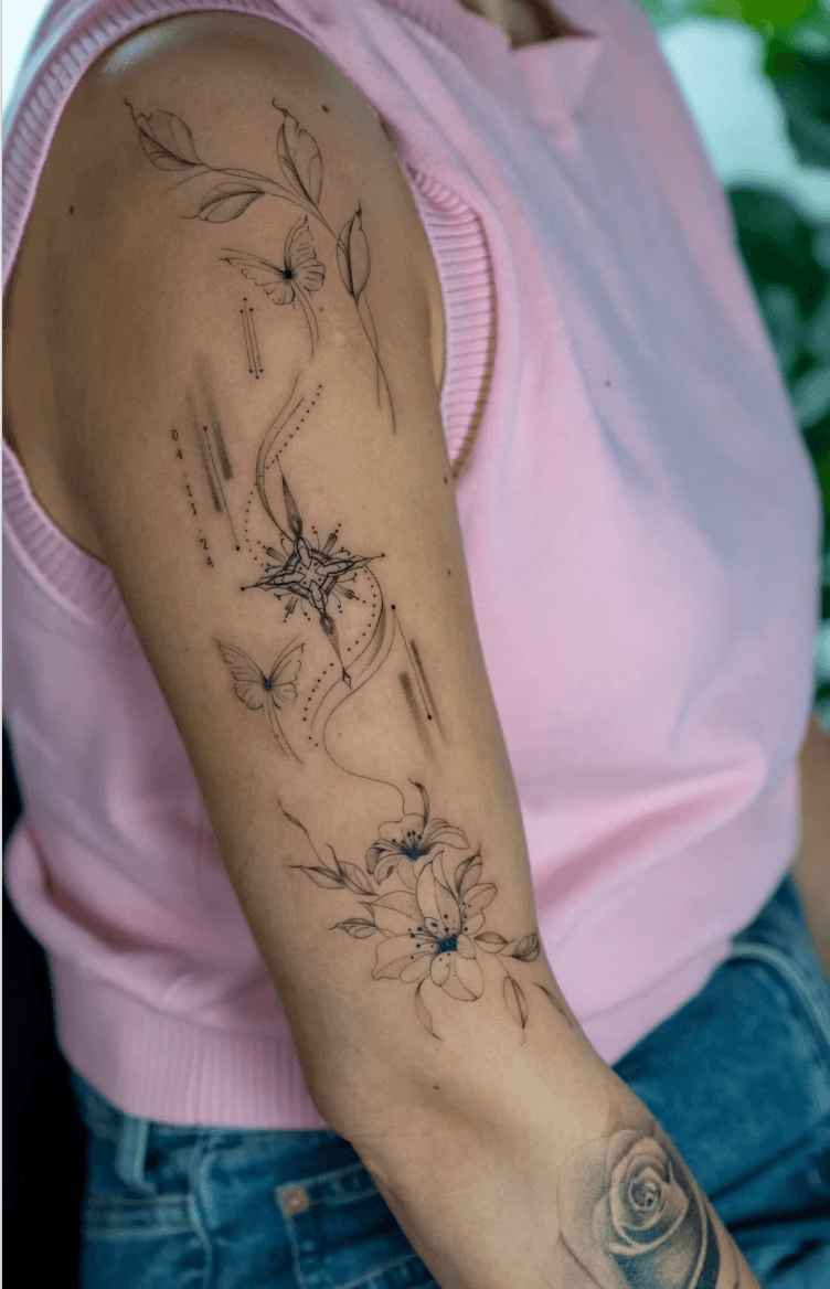 Elegant floral and butterfly tattoo with compass design.