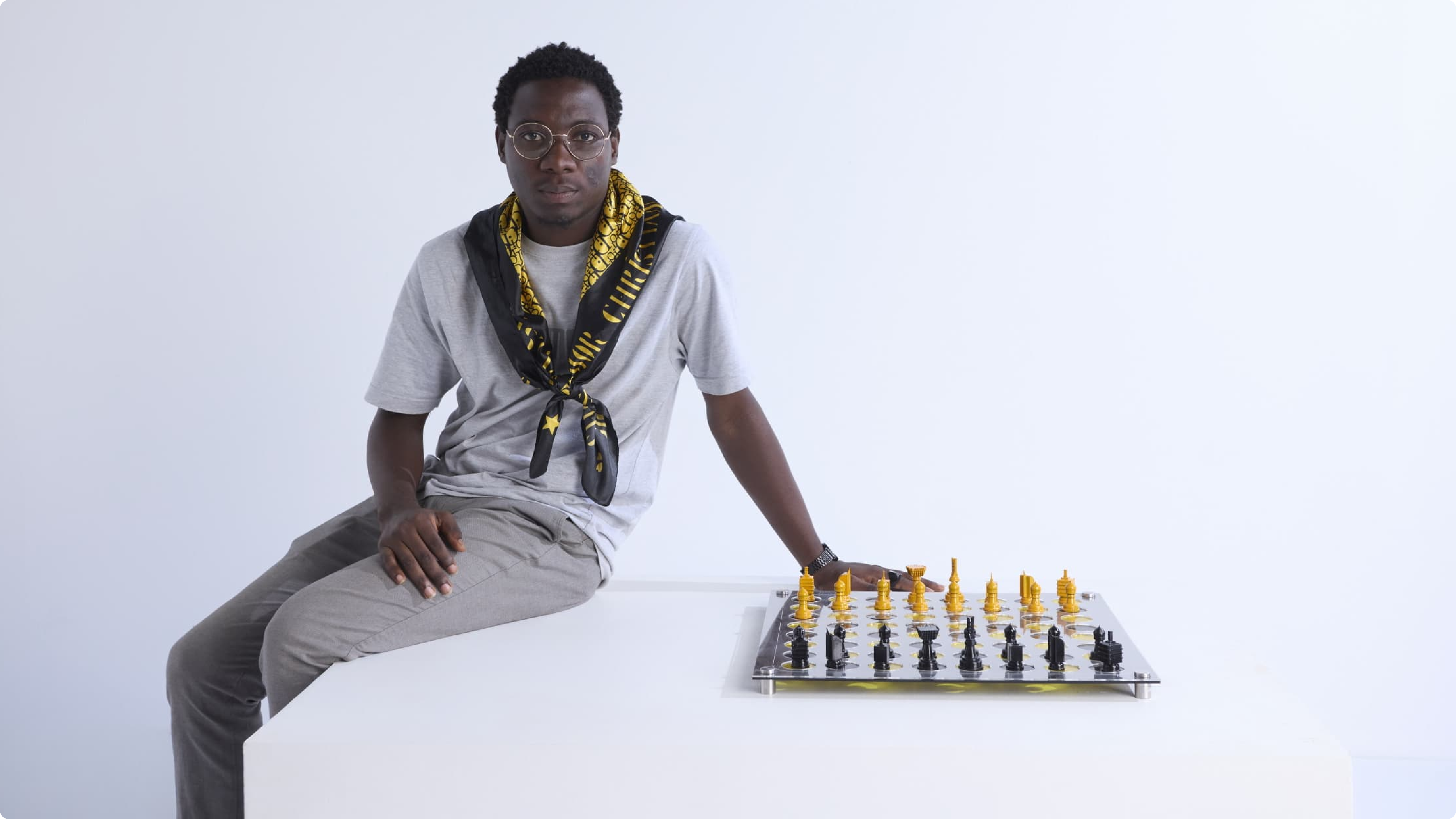 Black rectangular projecting sign mounted to a brick exterior wall, displaying “AVANT GALLERY” in light grey uppercase against the shadows and texture of the bricks.
