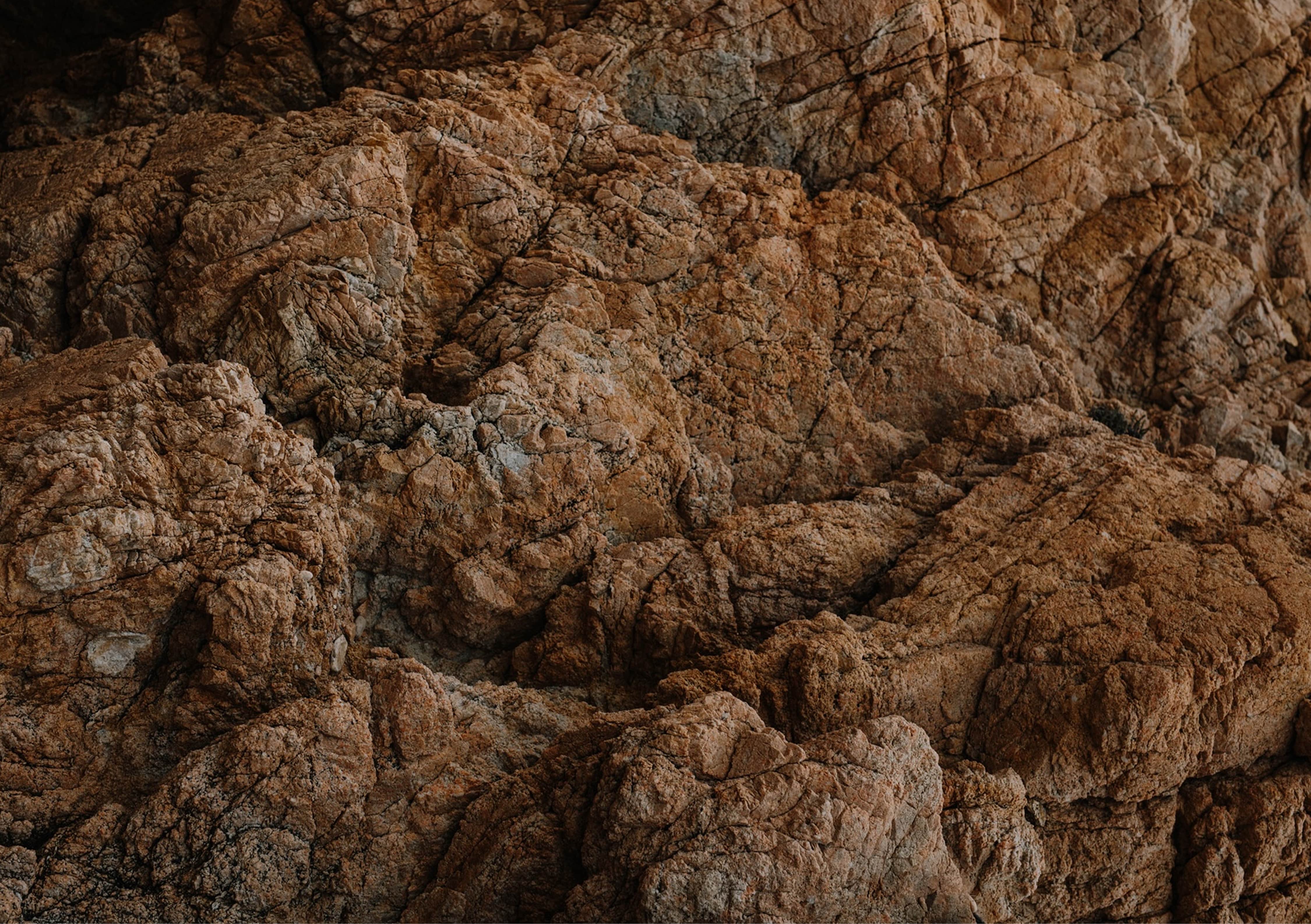 Tekstūruota uolėta formacija naudojama kaip fonas Ausvydas Baltuonis odontologijos ir implantologijos paslaugų puslapyje