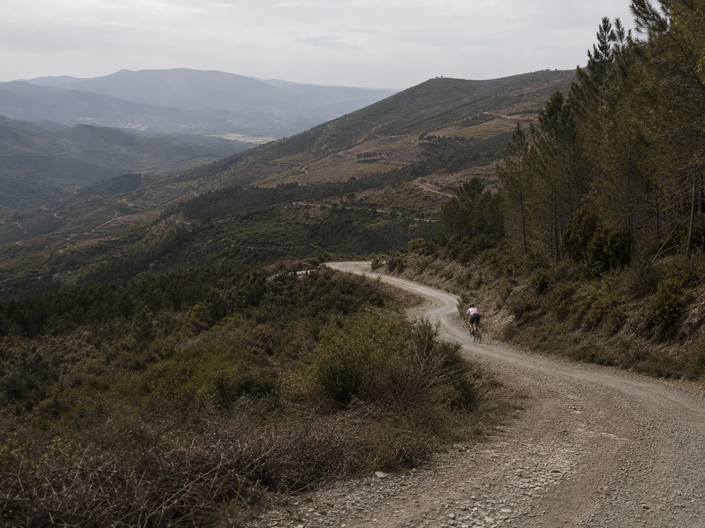 A cyclist descending a gravel road.
