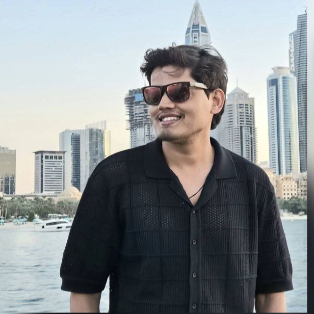 A businesswoman sitting at her desk, smiling and looking at the camera.