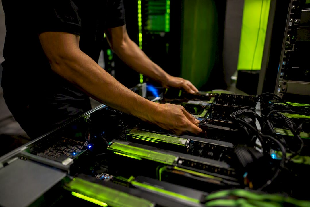 Hands adjusting AI hardware in neon-lit tech lab