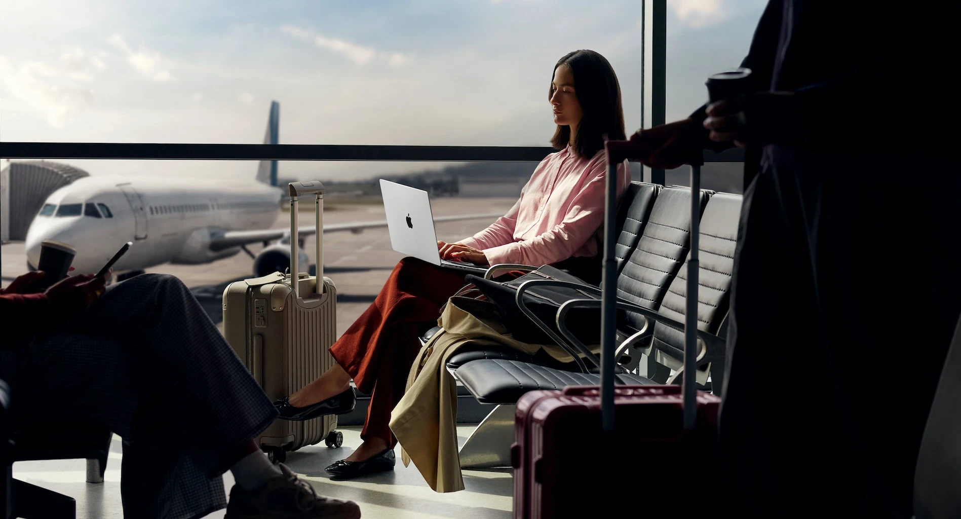 Woman typing on laptop sitting at airport lounge