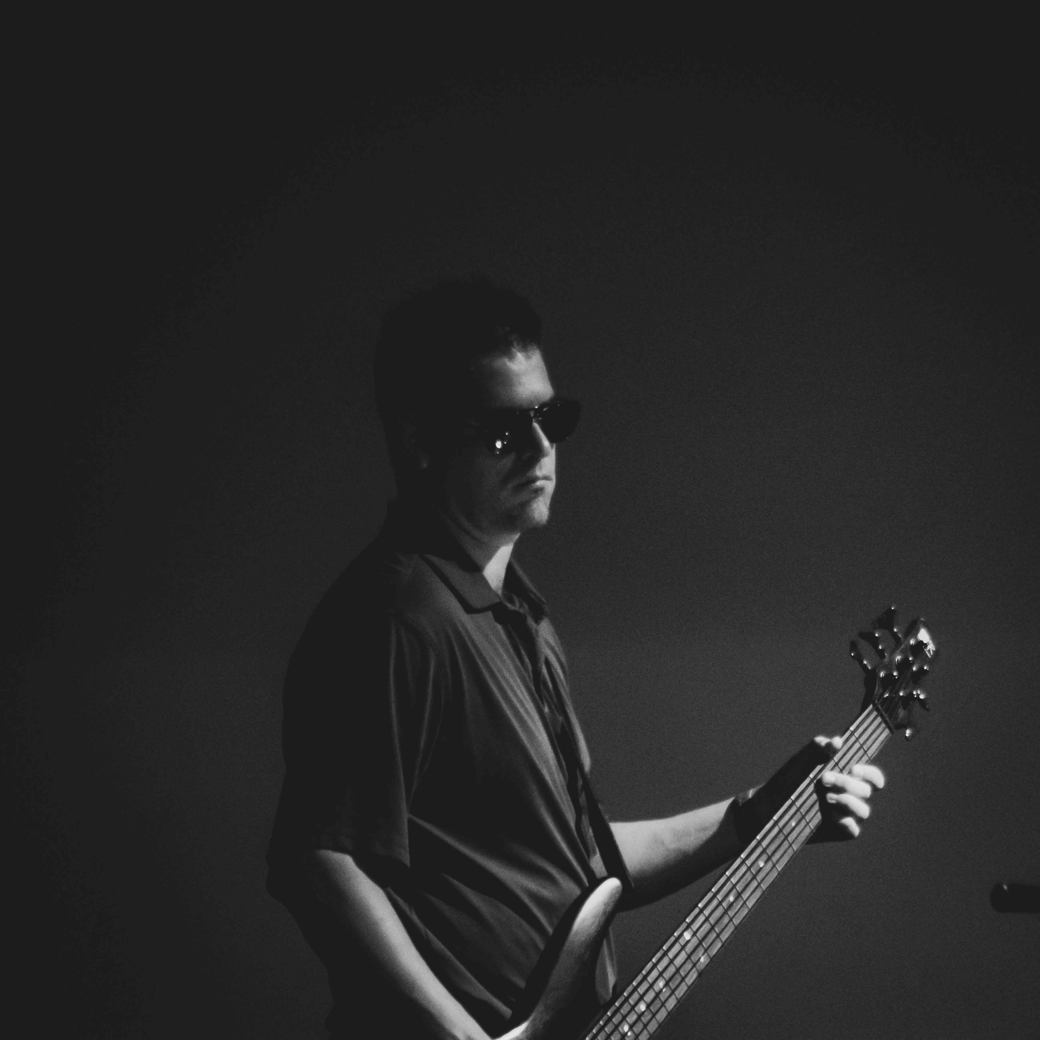 man in black crew neck t-shirt playing acoustic guitar