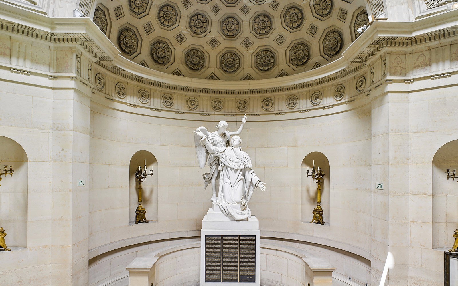 巴黎赎罪礼拜堂内部的雕像，配有华丽的天花板和烛台。