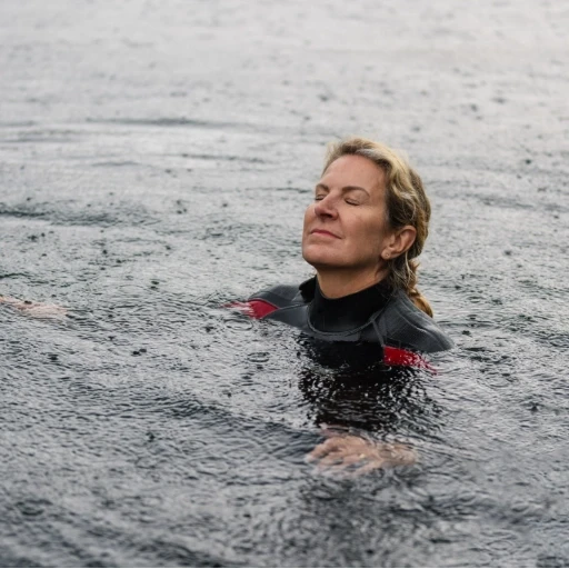 Person enjoying cold water swimming therapy in natural outdoor water