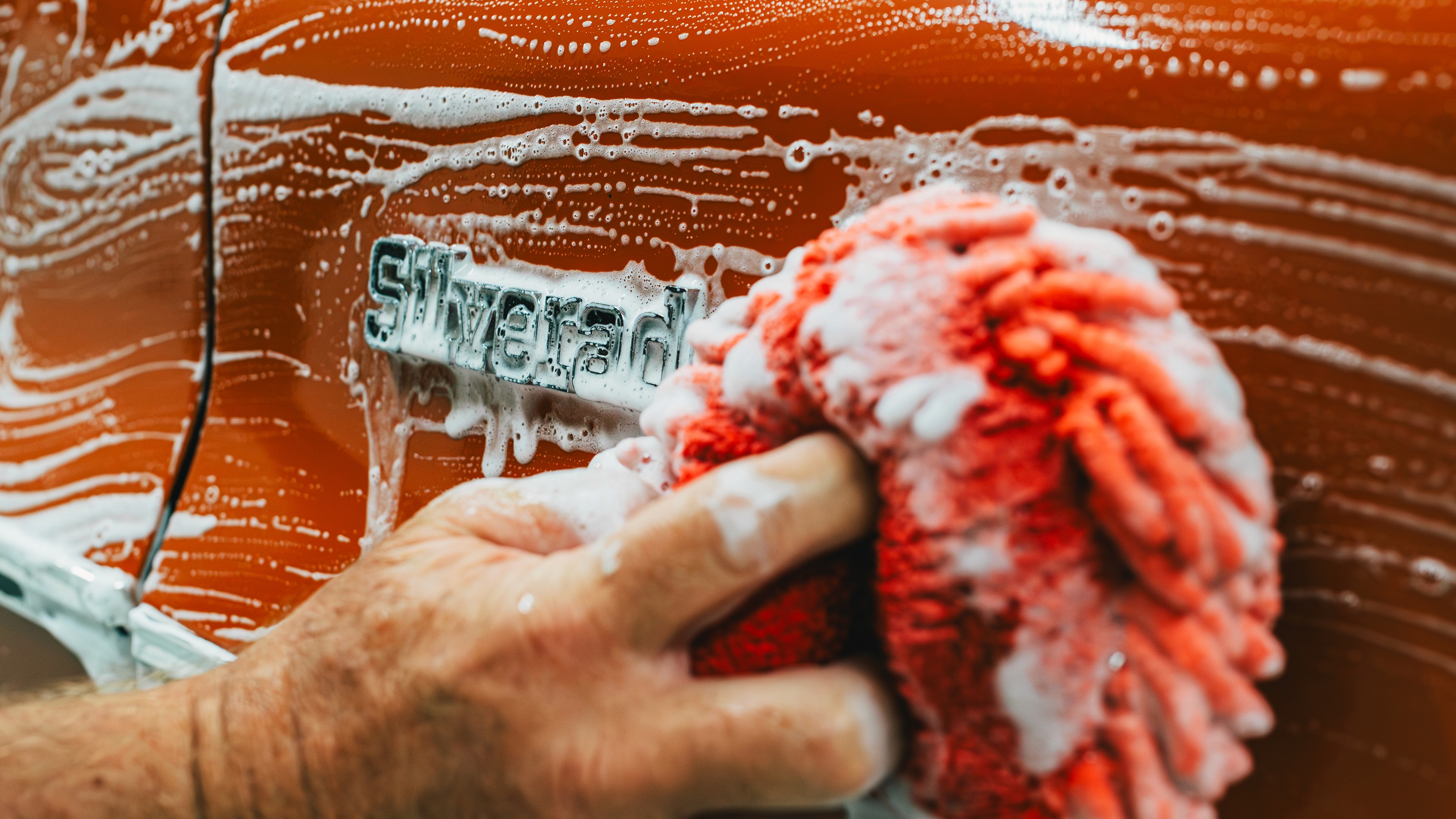 Close-up of black road bike with bright orange frame accents.