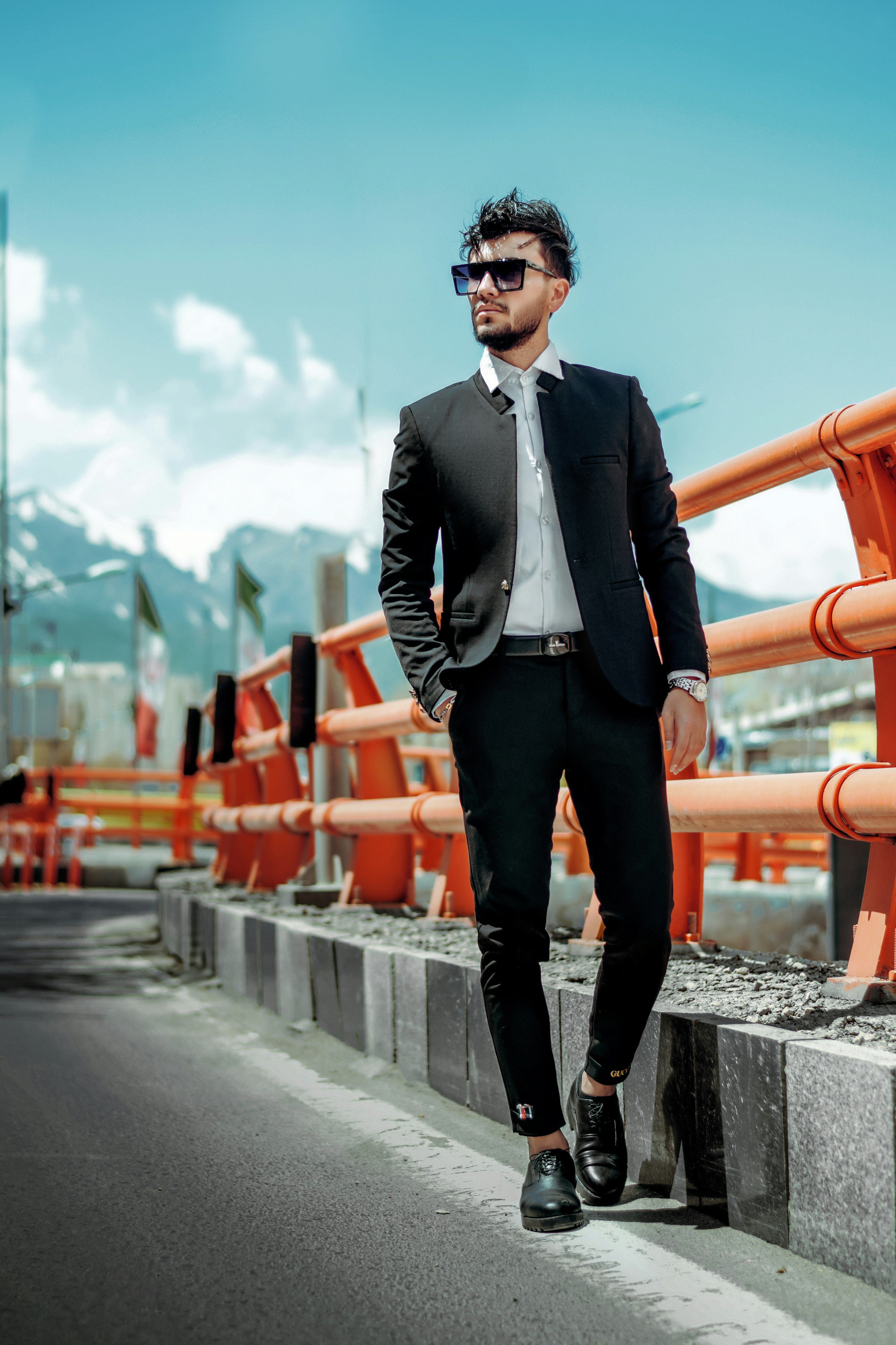 man in black suit standing on gray concrete road during daytime