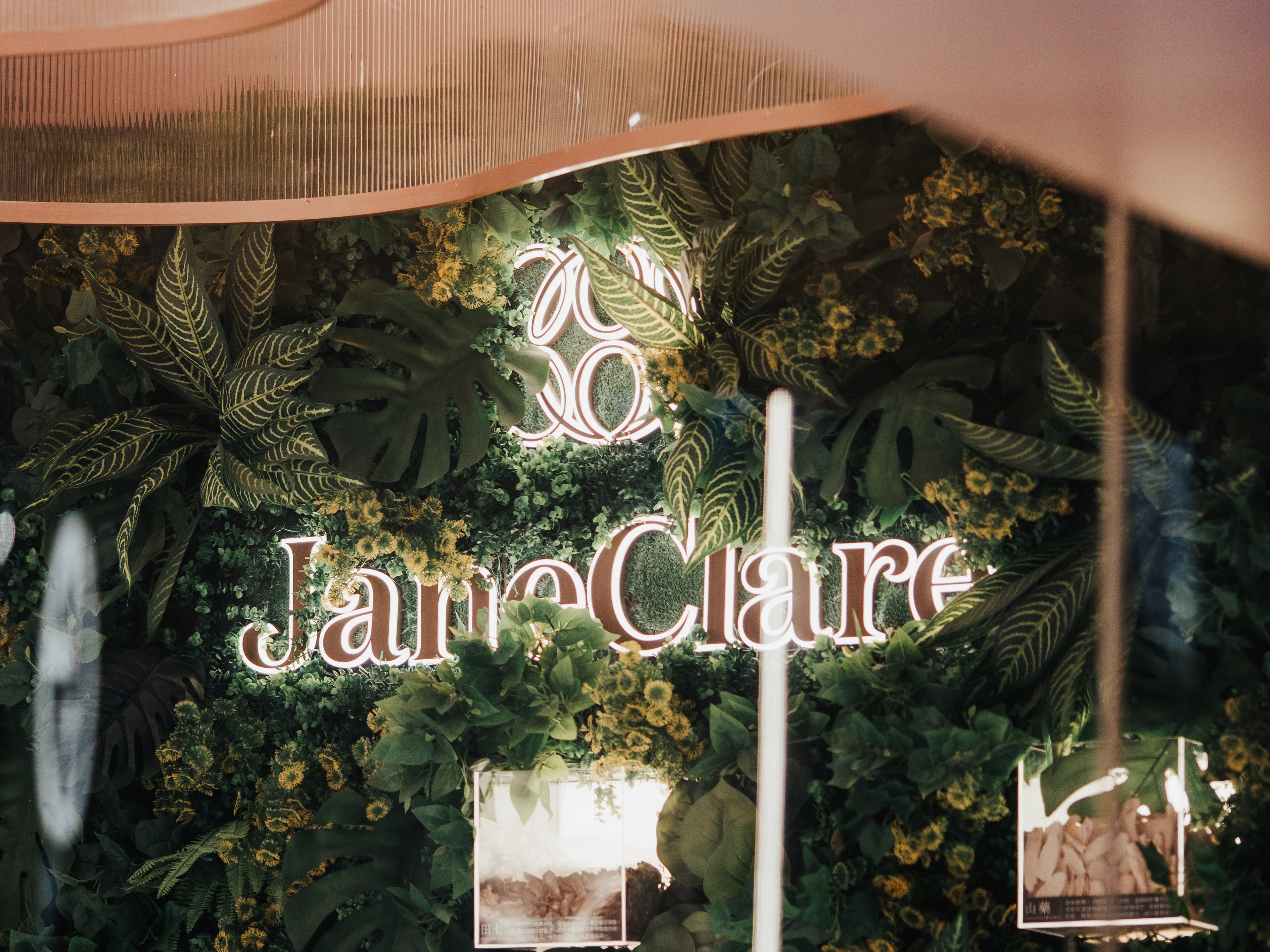 An interior detail shot showcasing a green wall with a neon sign for the brand, highlighting the store's wellness gallery concept.