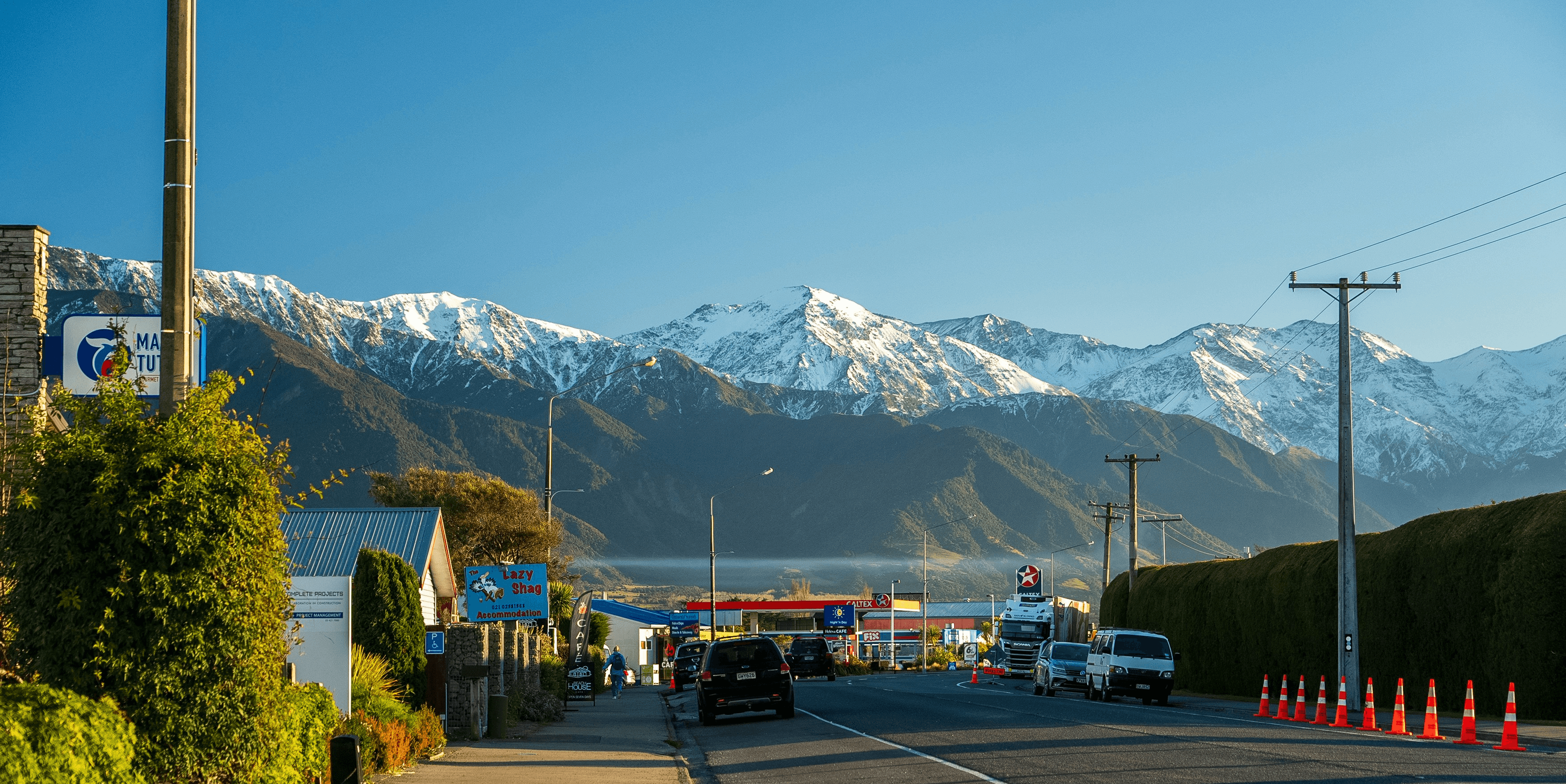 A car driving down a road with mountains in the background