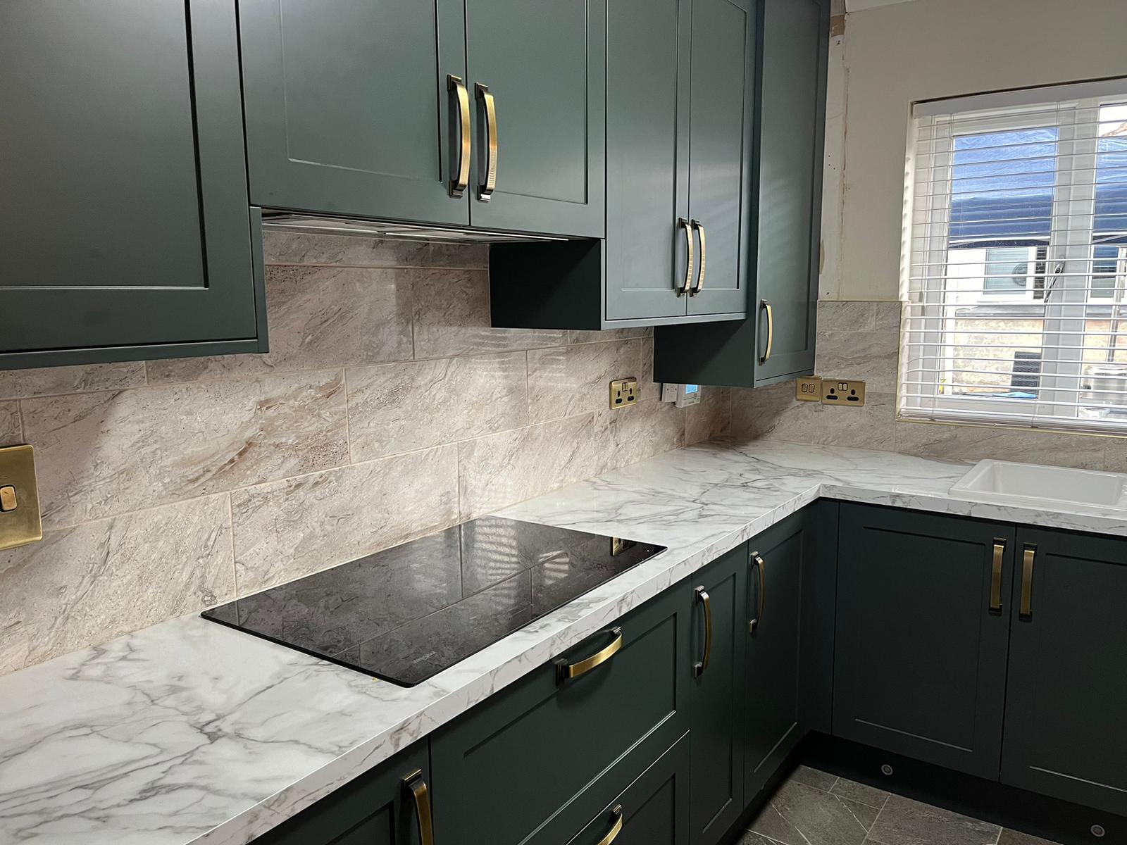 A modern house with large windows and a flat roof, surrounded by greenery against a clear blue sky.