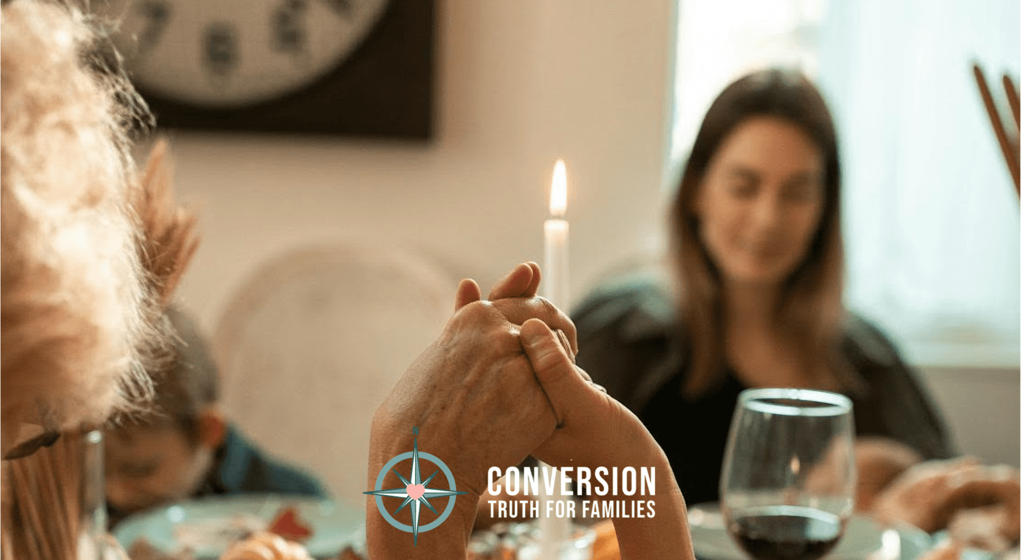 Conversion Truth for Families - Family sitting around dinner table, holding hands in prayer