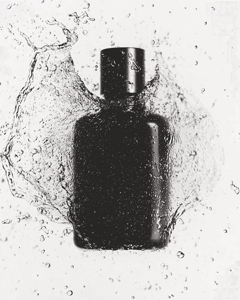 A luxury black bottle with splashing liquid.