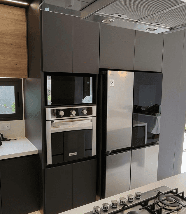 A serene outdoor seating area with two chairs, surrounded by lush greenery and a glassed-in structure.