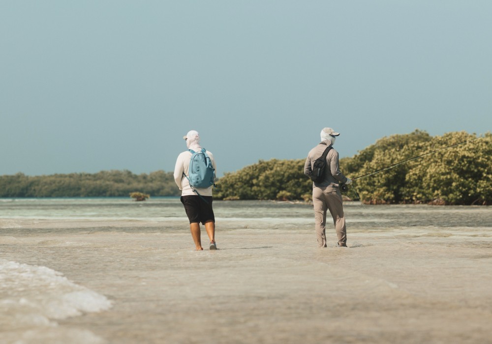 Fly fishing guide and angler vading shallow flats outside Placencia