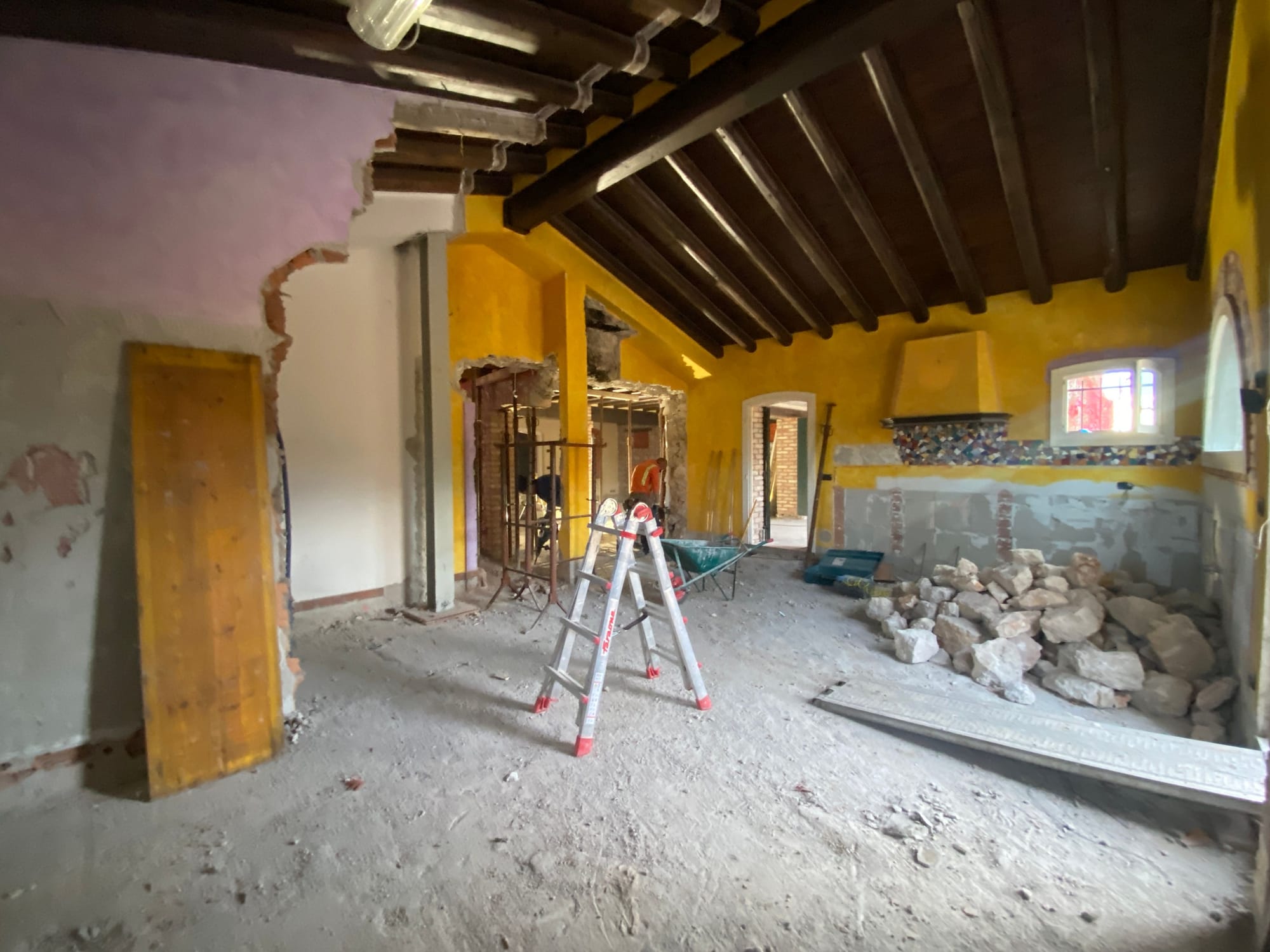 Ground floor with yellow walls and exposed beams before the renovation