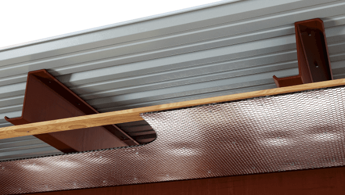 person writing on brown wooden table near white ceramic mug