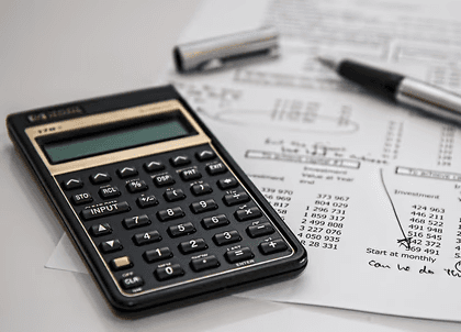 Calculator and financial paperwork representing insurance premium calculations and business cost planning.