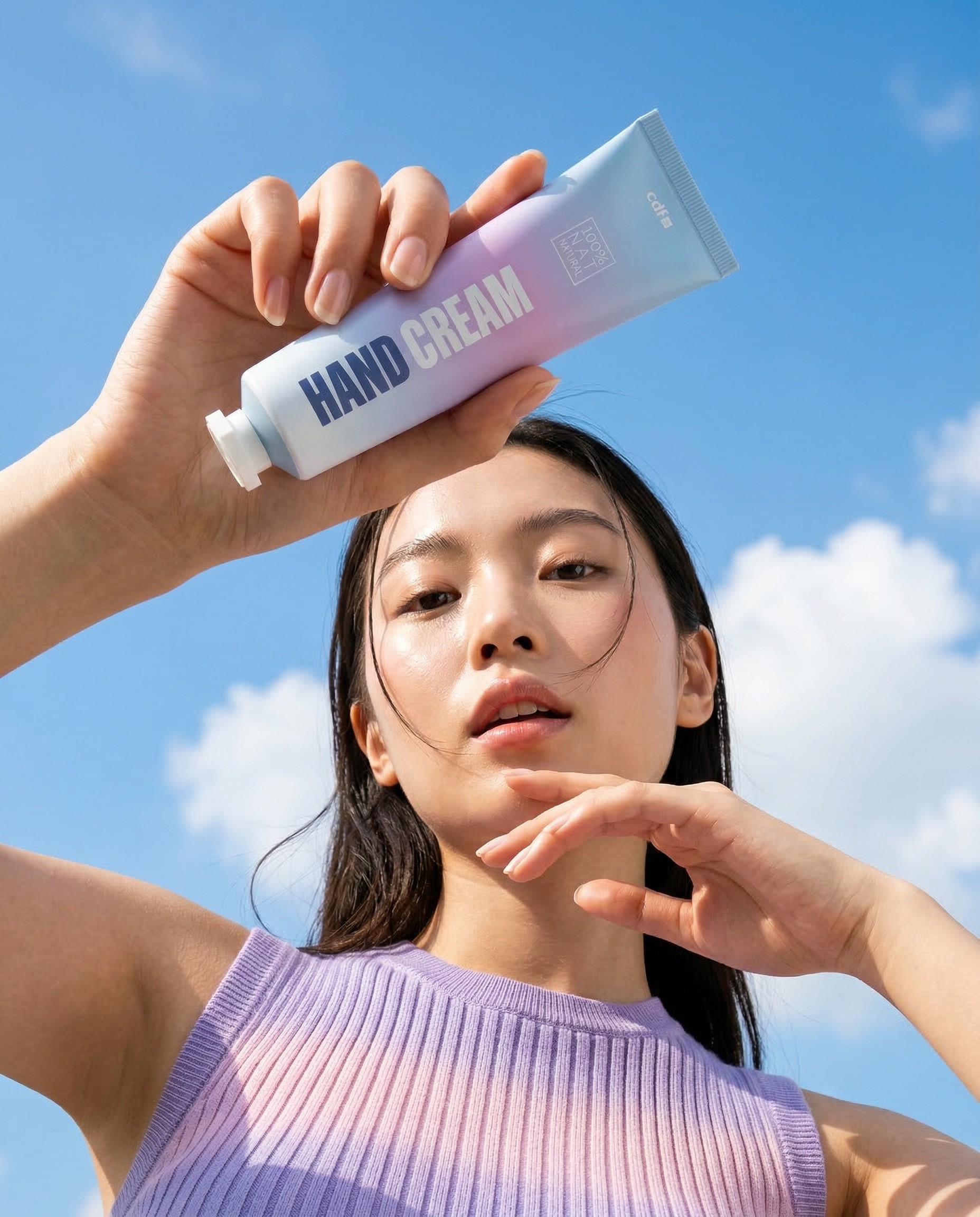 Close-up portrait of a person wearing a gray insulated hooded jacket with the hood up, showing their face framed by the hood against a light background.