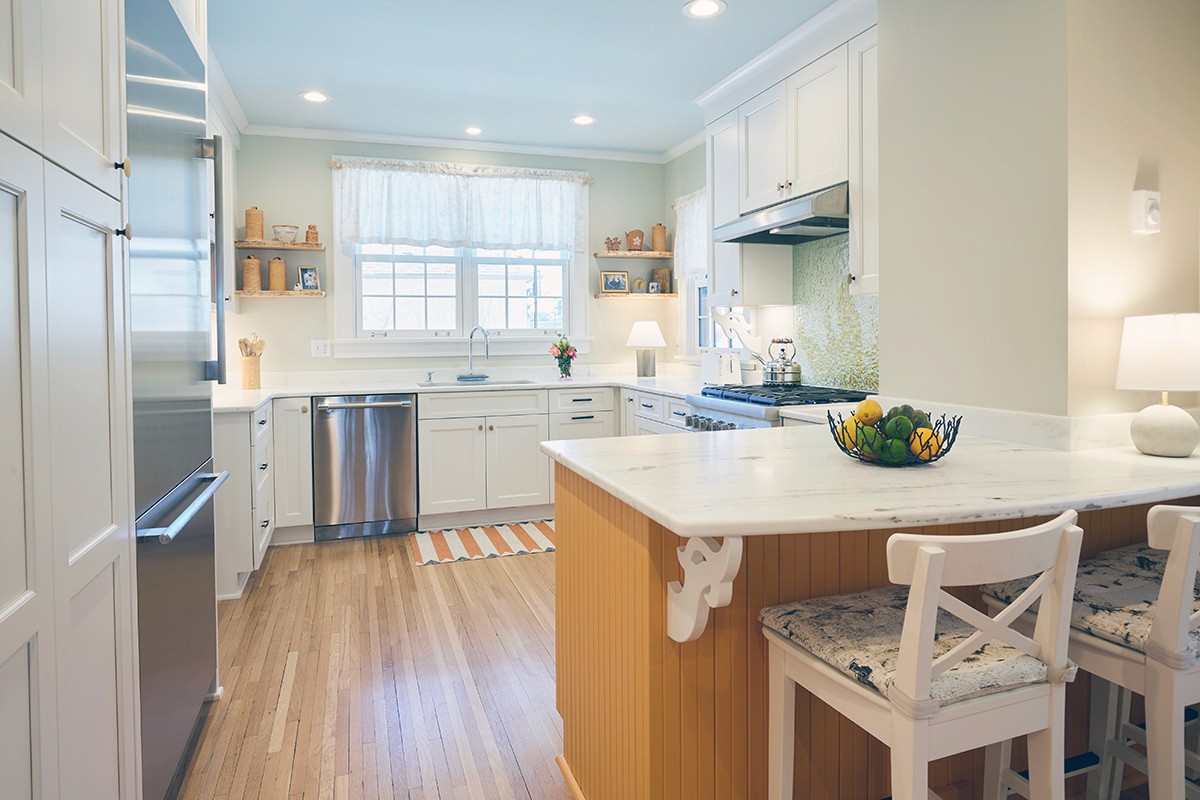 White Shaker cabinets, marble counters, and beadboard peninsula in the Linden Hills kitchen, Minneapolis