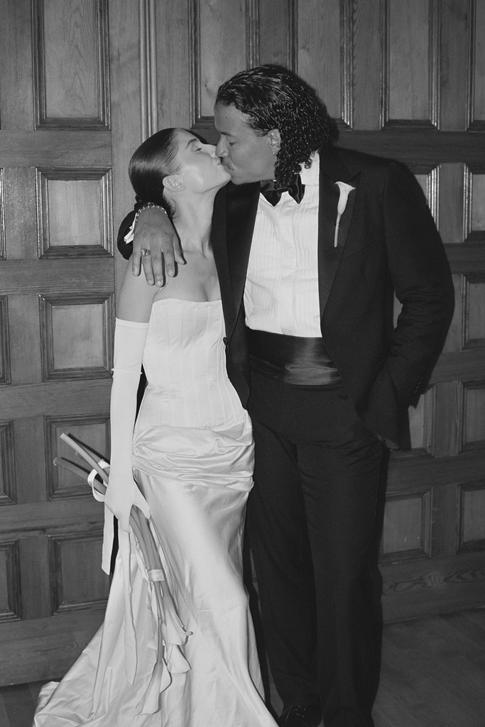 Black-and-white portrait of a bride and groom kissing against wooden paneling at a Montréal wedding