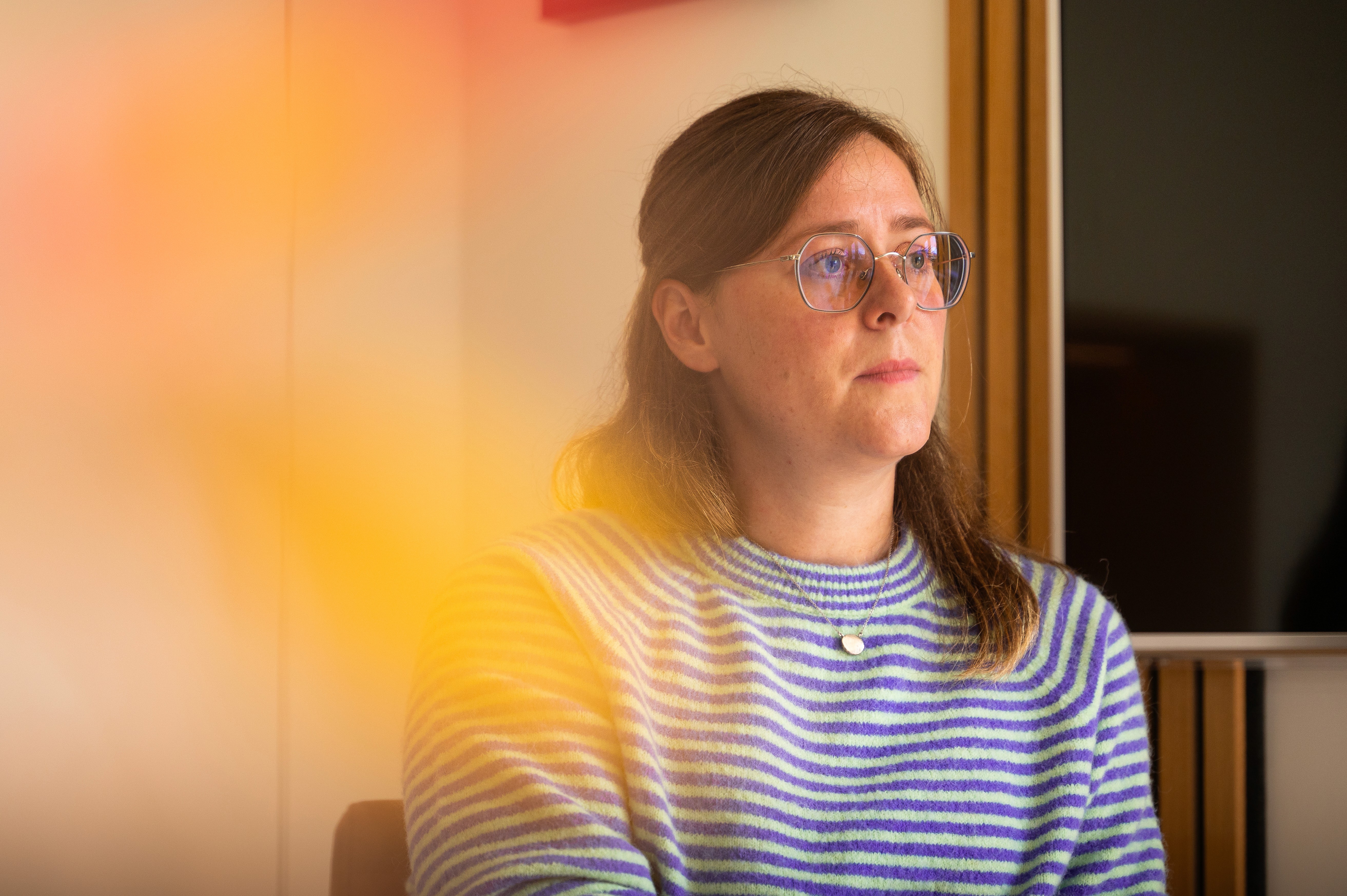 A gray langur monkey sits on a metal railing.