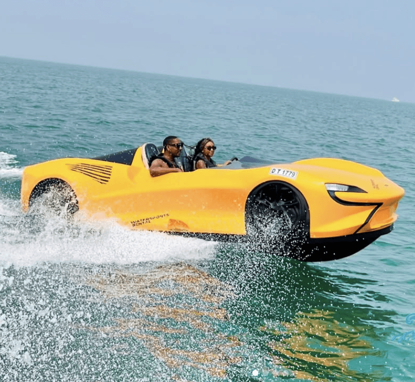A couple driving a yellow jet car on the water during a water adventure in Dubai.
