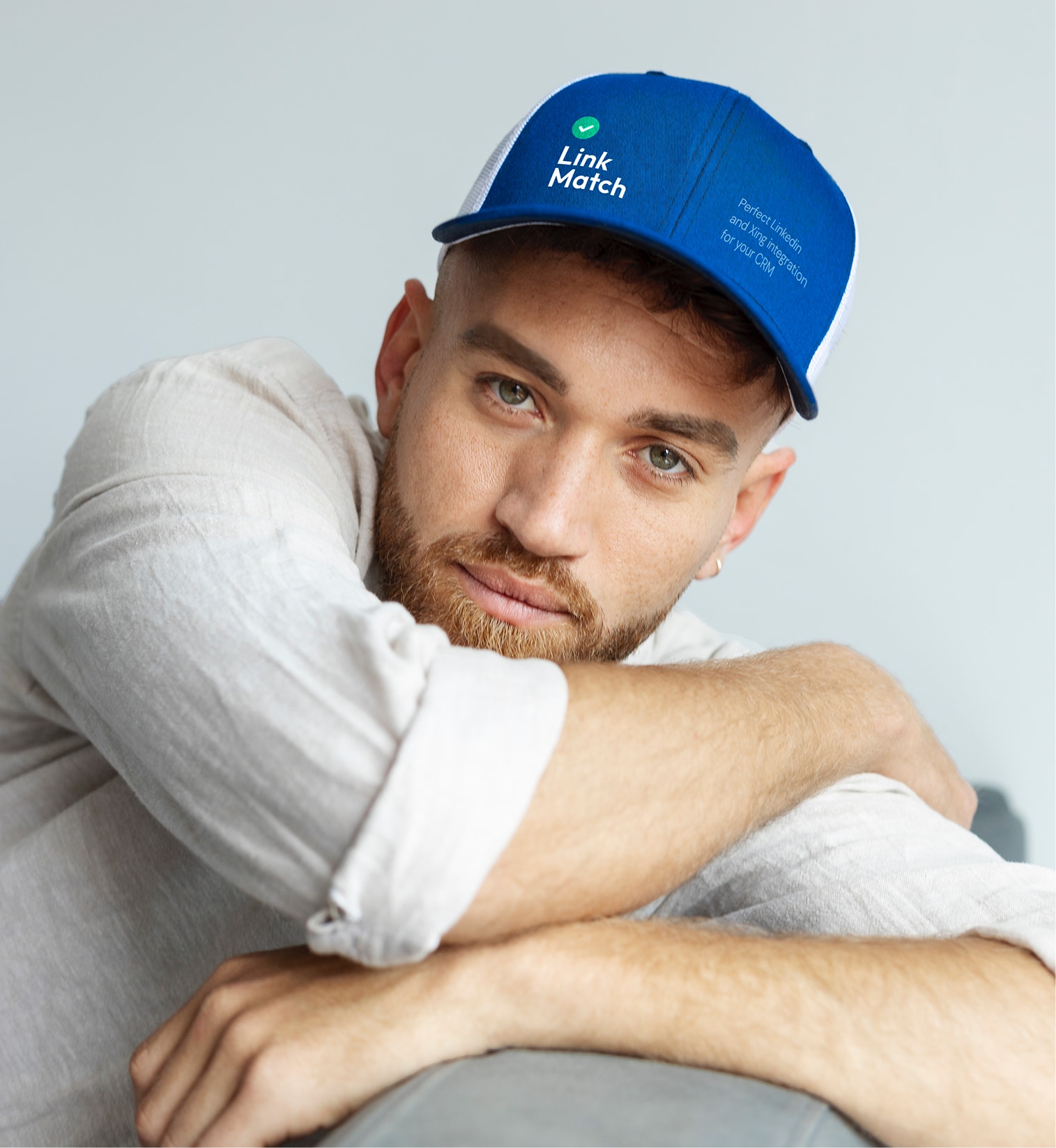 Individual wearing a blue LinkMatch branded hat as part of company merchandise