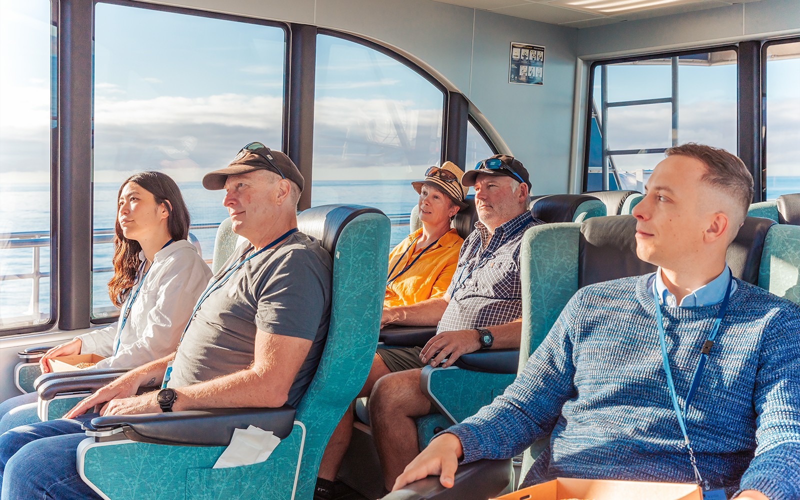 Passagiere sitzen während einer Walbeobachtungskreuzfahrt in Kaikoura in einem Boot.