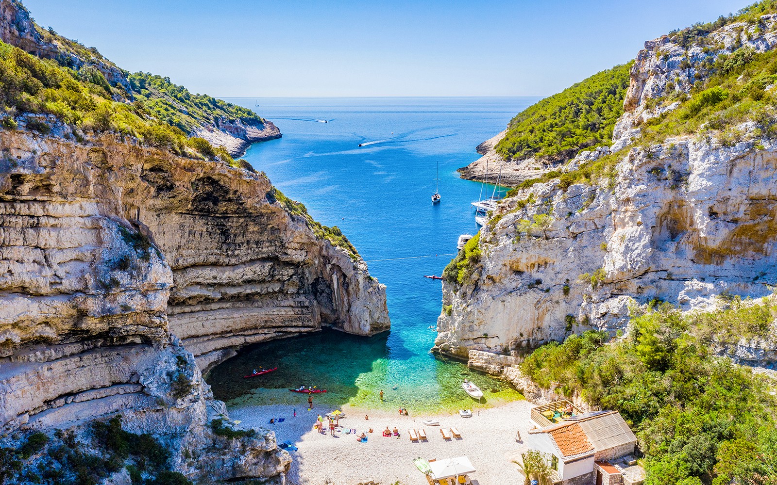 Blå grottan och Vis Älands strand med båtar och turister, Kroatien.