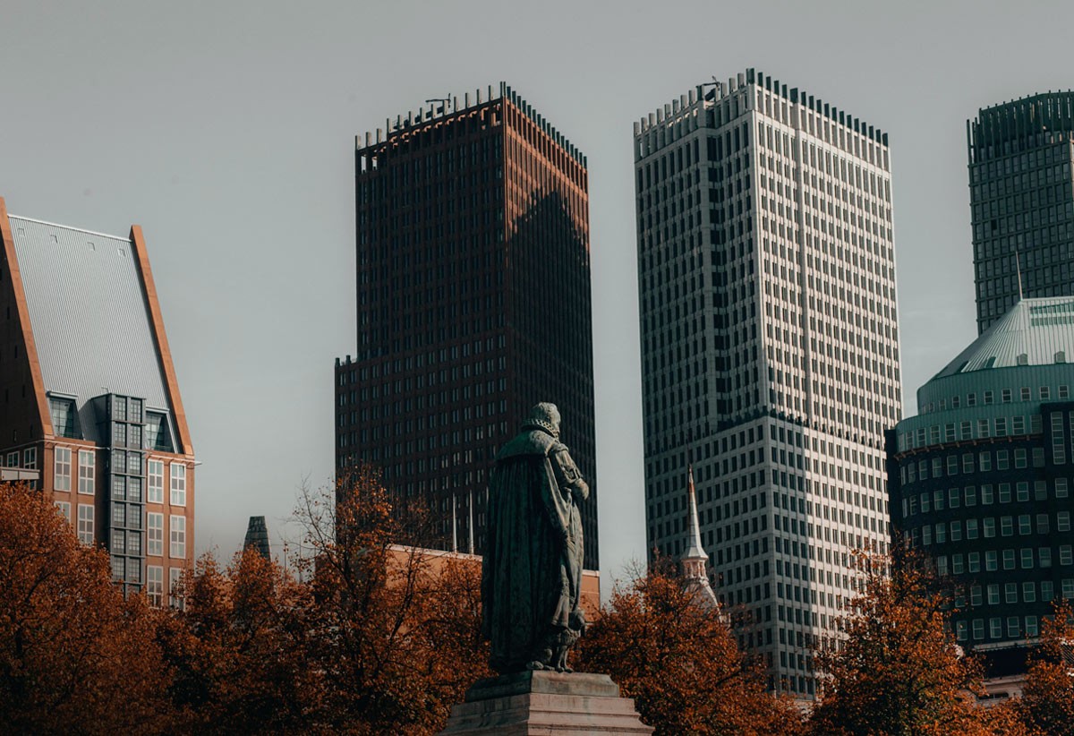 The Hague, in The Netherlands at autumn time, showing a contrast of old statue in front of new buildings