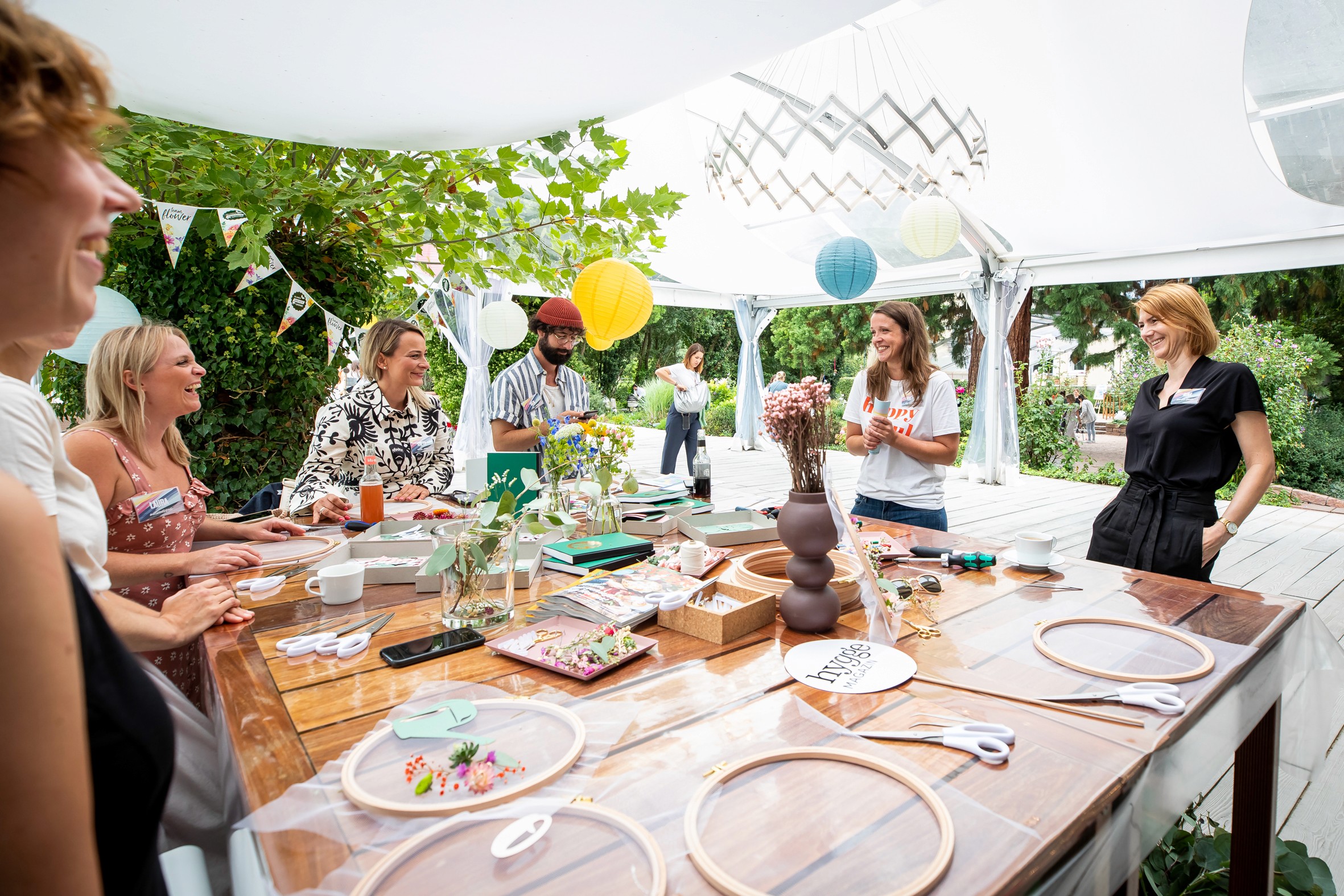 Gemeinsam mit 1000 gute Gründe für Blumen und Pflanzen gestalten die Creator  Blumen-Wallhangings mit Tüll, Blüten und Schriftzügen.